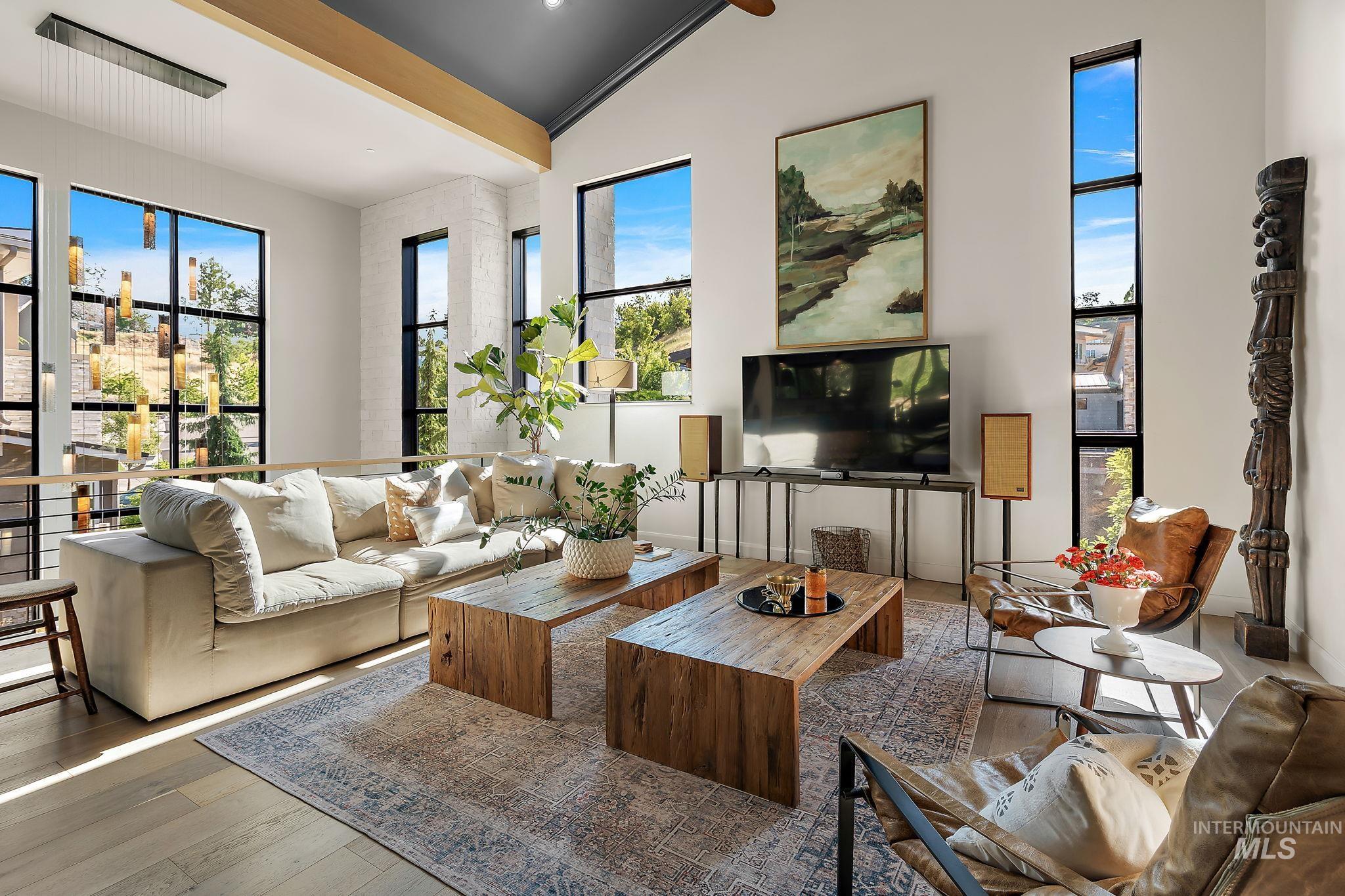 Vaulted living room featuring light wood-finish flooring and a dark accent ceiling