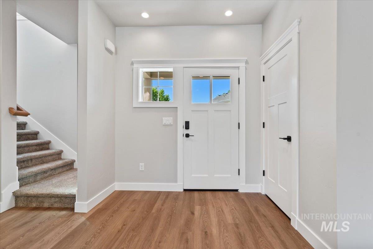 Entrance foyer featuring light wood-type flooring, stairway, and recessed lighting