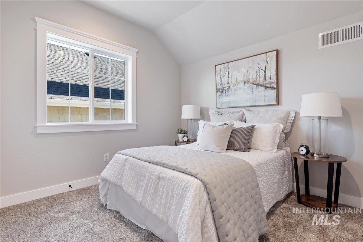 Bedroom with carpet flooring and vaulted ceiling