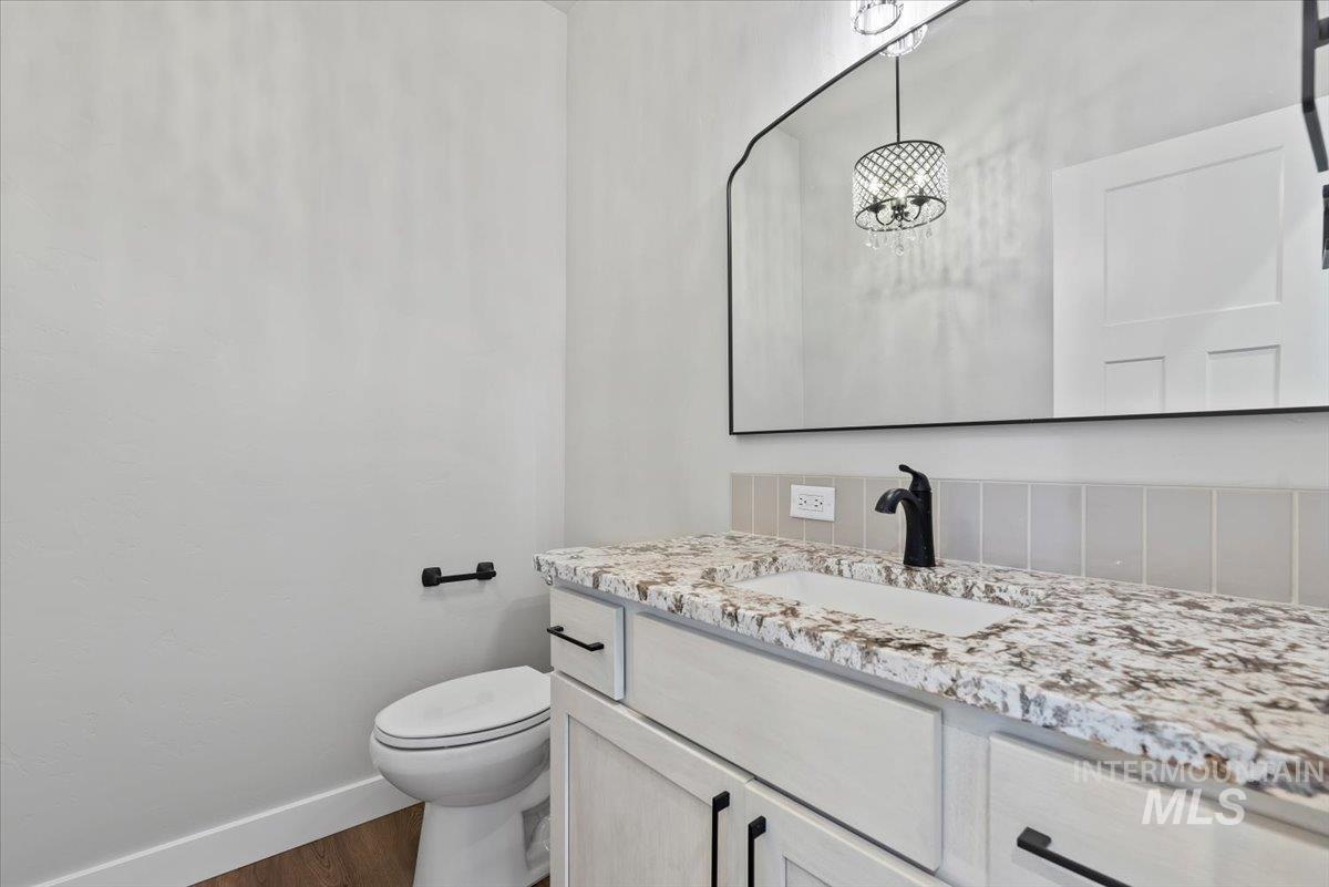 Half bath featuring vanity and wood finished floors