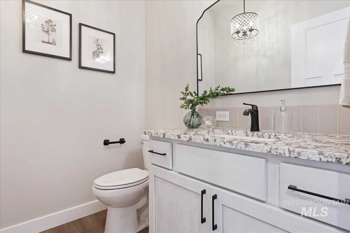 Half bathroom with vanity and wood finished floors