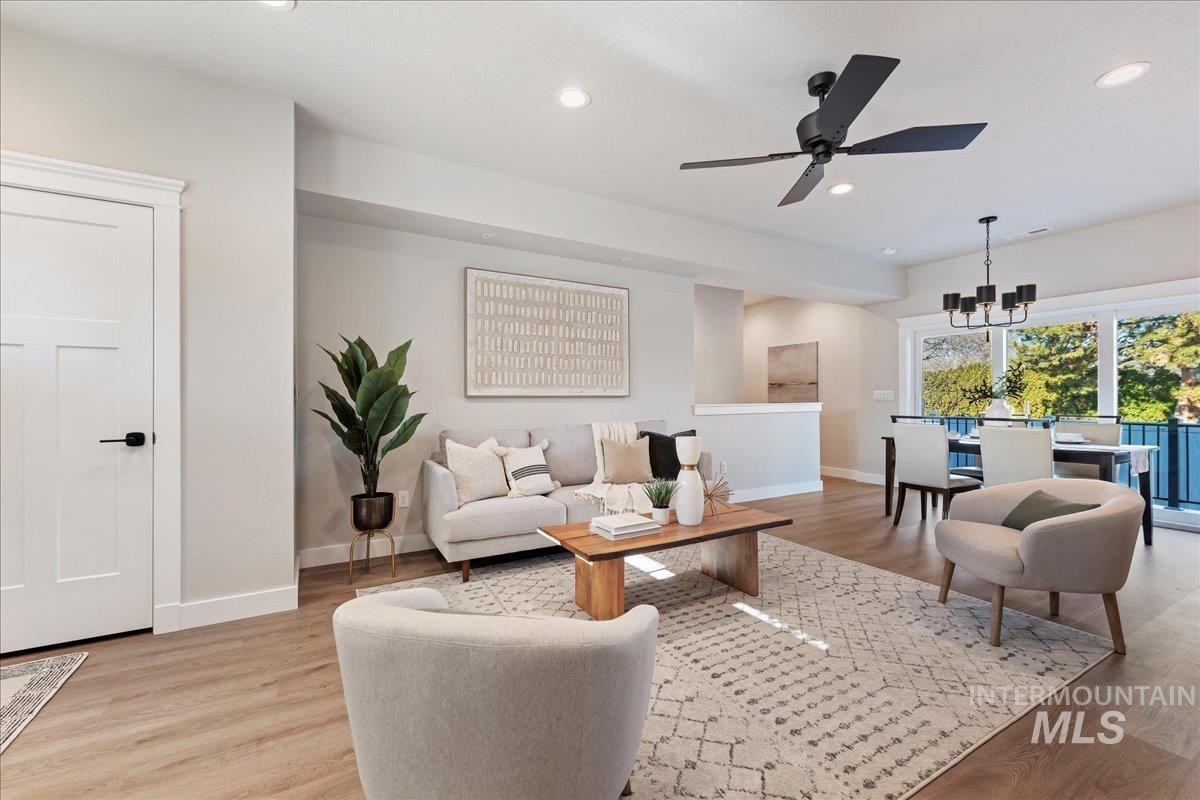Living area with light wood-type flooring, recessed lighting, a chandelier, and ceiling fan