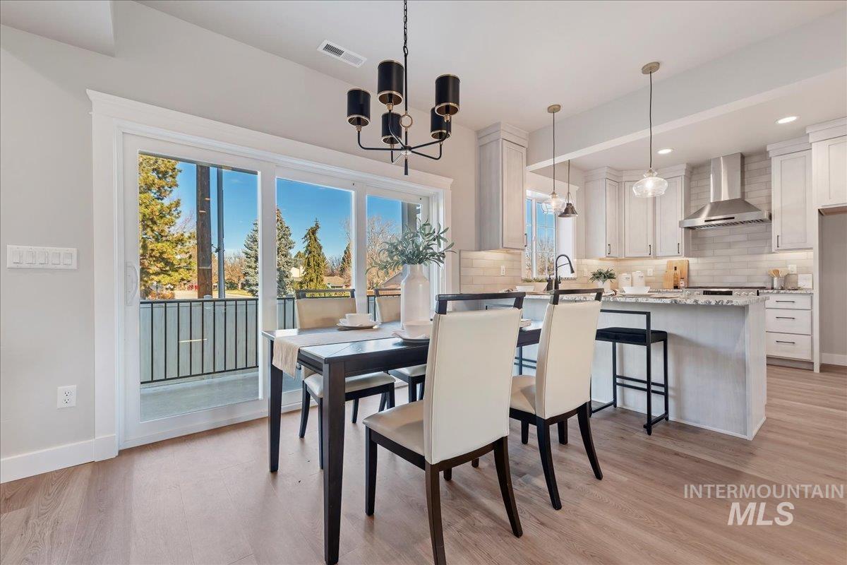 Dining space featuring light wood finished floors, a chandelier, and recessed lighting