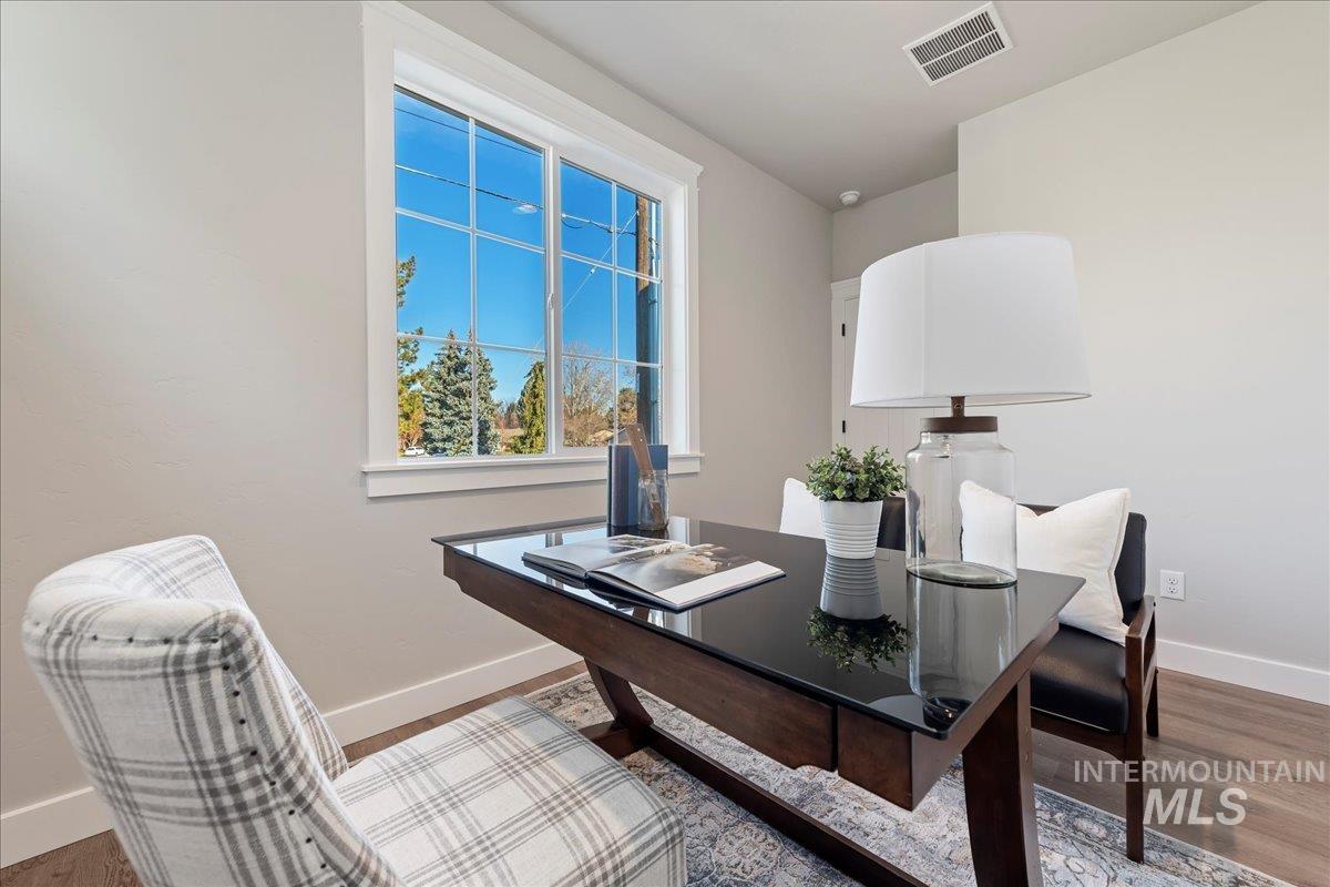 Home office with baseboards and wood finished floors