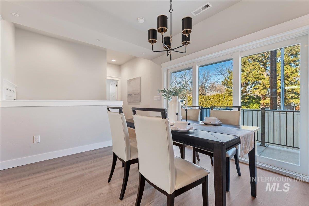 Dining area with light wood-type flooring, a chandelier, and recessed lighting