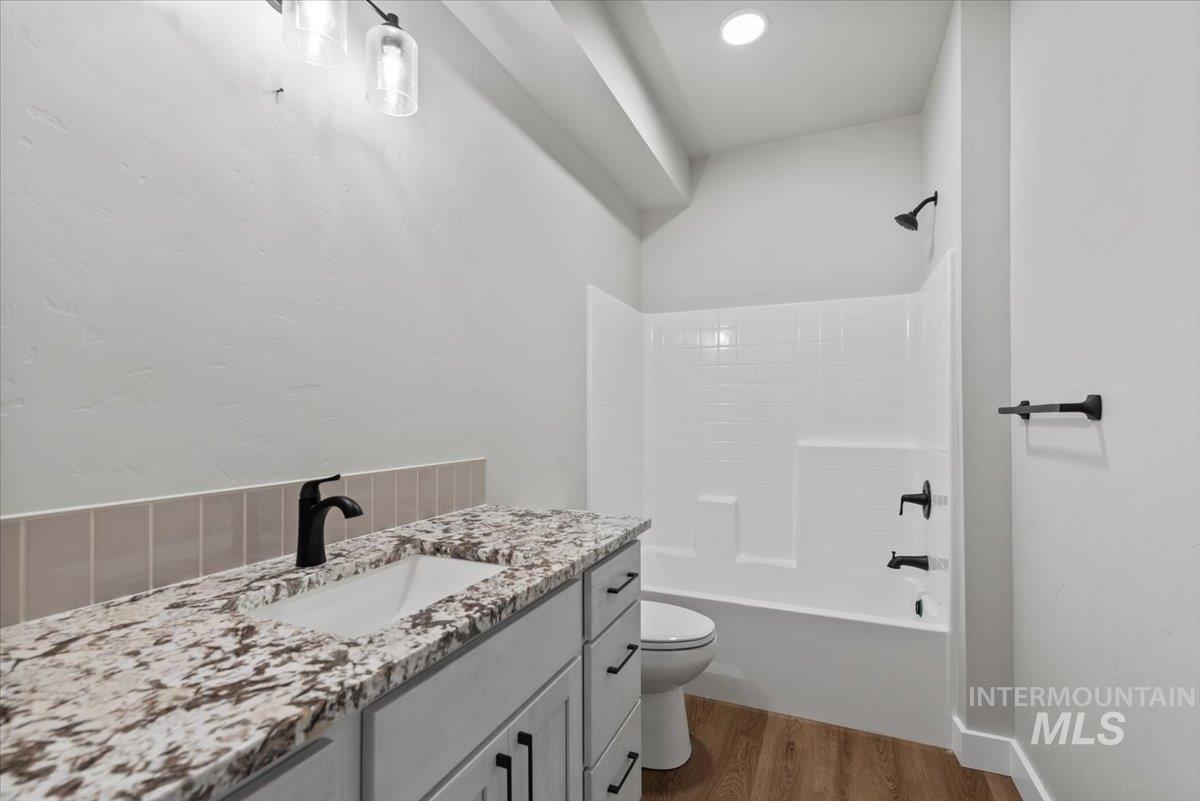Full bathroom with vanity, wood finished floors, and bathtub / shower combination
