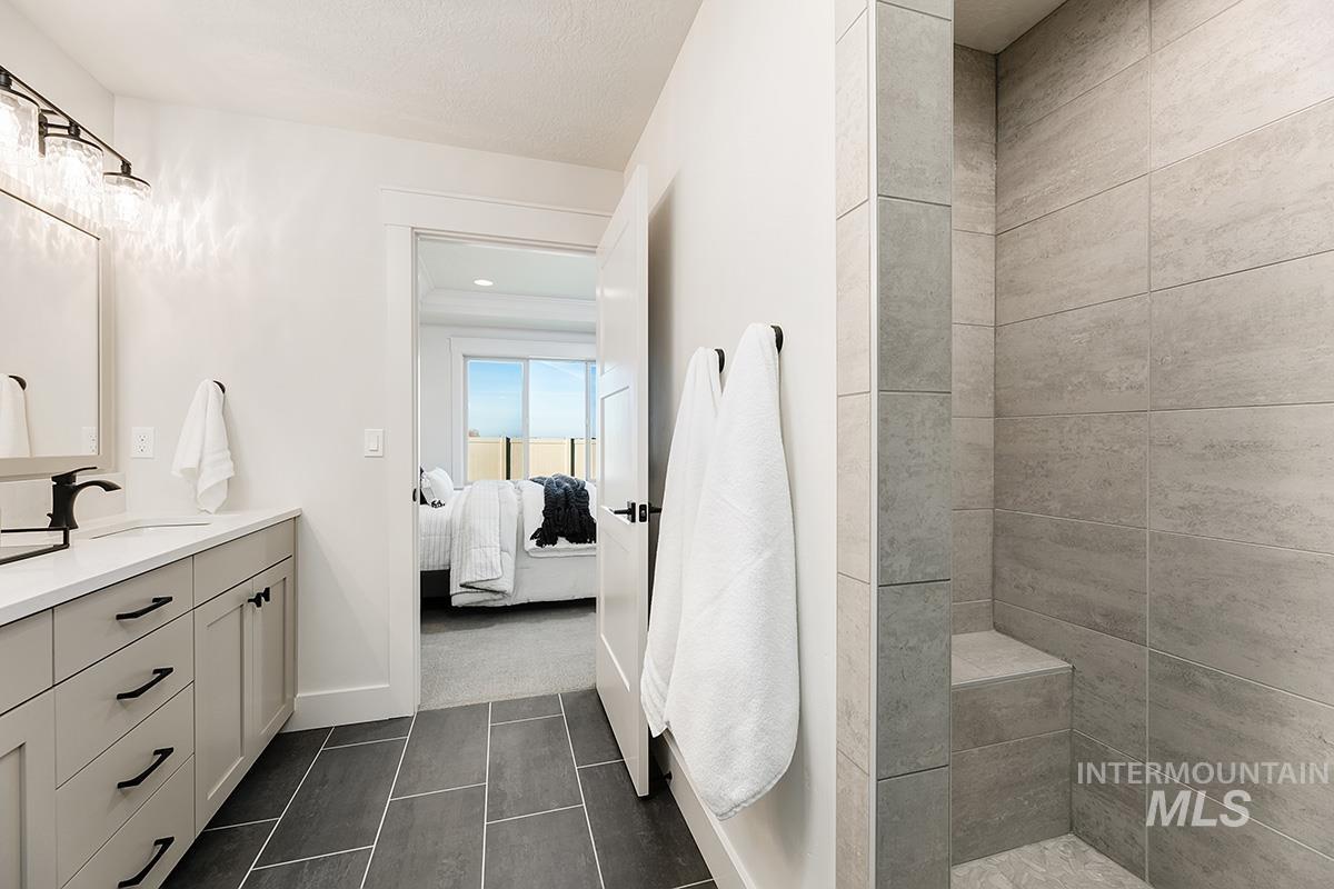 Bathroom featuring a vanity with an undermount sink, quartz countertop, and matte black faucet