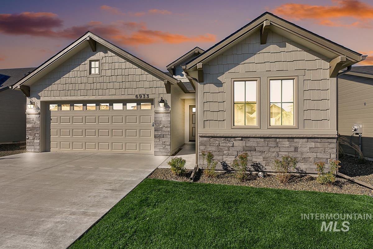 Contemporary exterior featuring stone accents, shake siding, and a two-car garage with transom windows