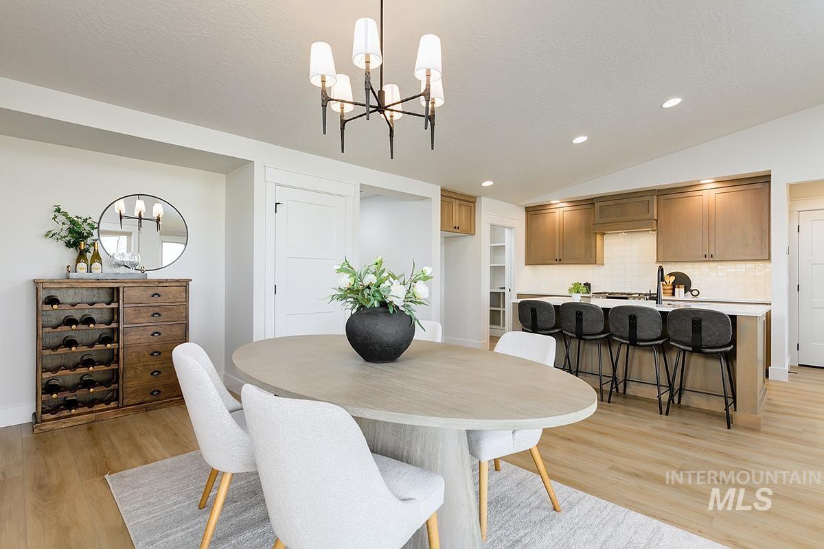Open-concept living space featuring wood-finish flooring, a modern chandelier, and recessed lighting
