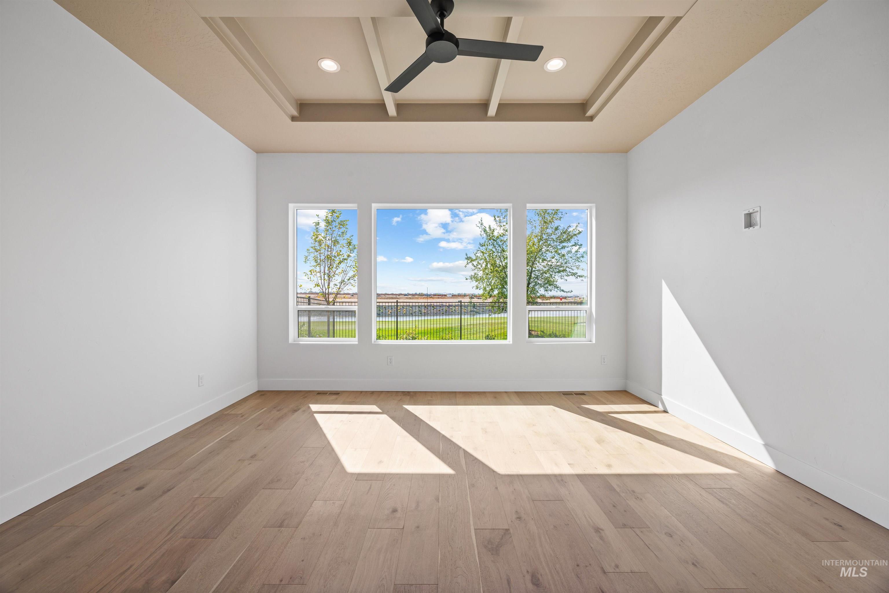 Empty room with light wood-style floors, a ceiling fan, beam ceiling, recessed lighting, and coffered ceiling
