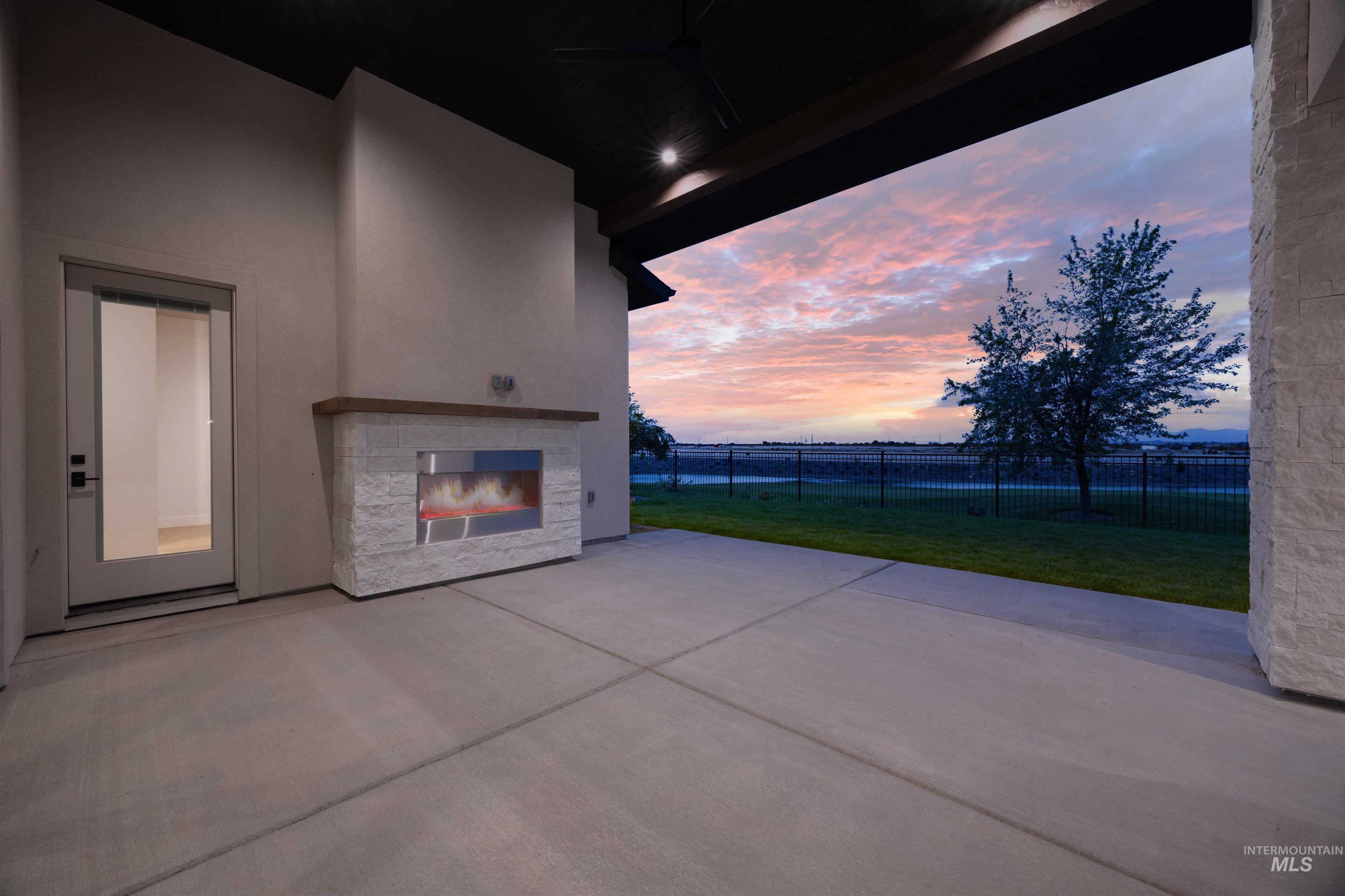 View of patio / terrace featuring an outdoor stone fireplace and a ceiling fan