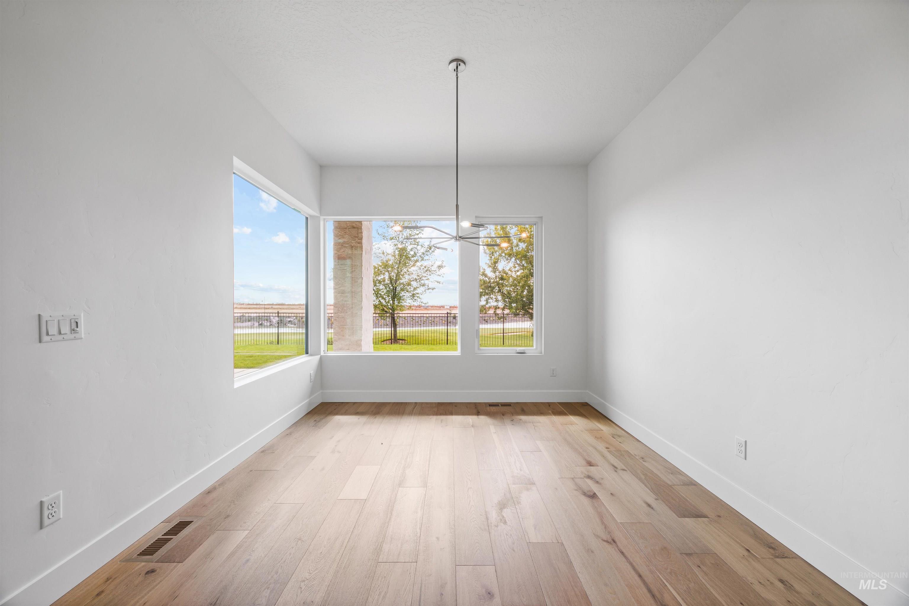 Unfurnished dining area with light wood-style floors and healthy amount of natural light