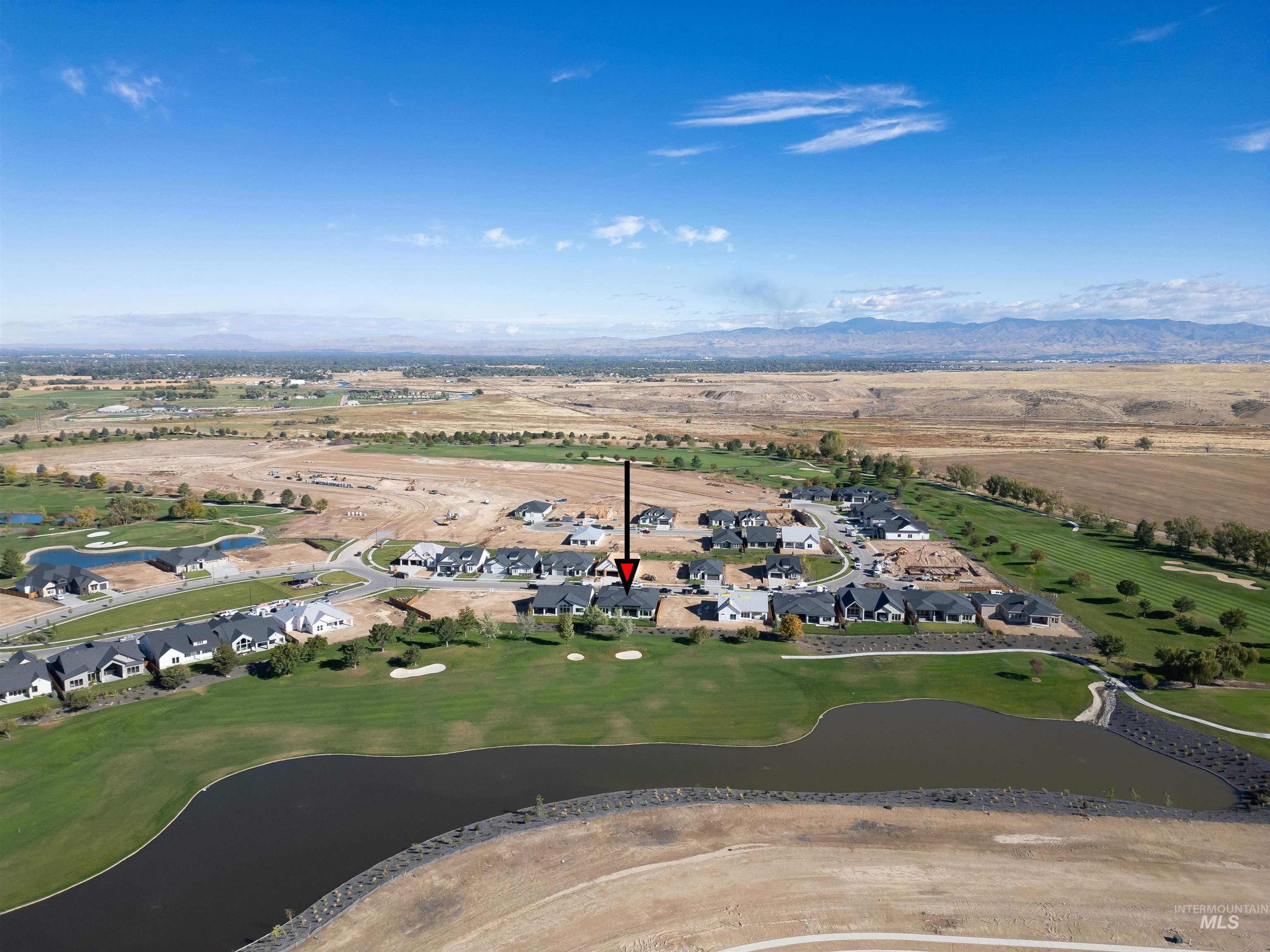 Aerial view of property's location featuring nearby suburban area, a water and mountain view, and a local golf course