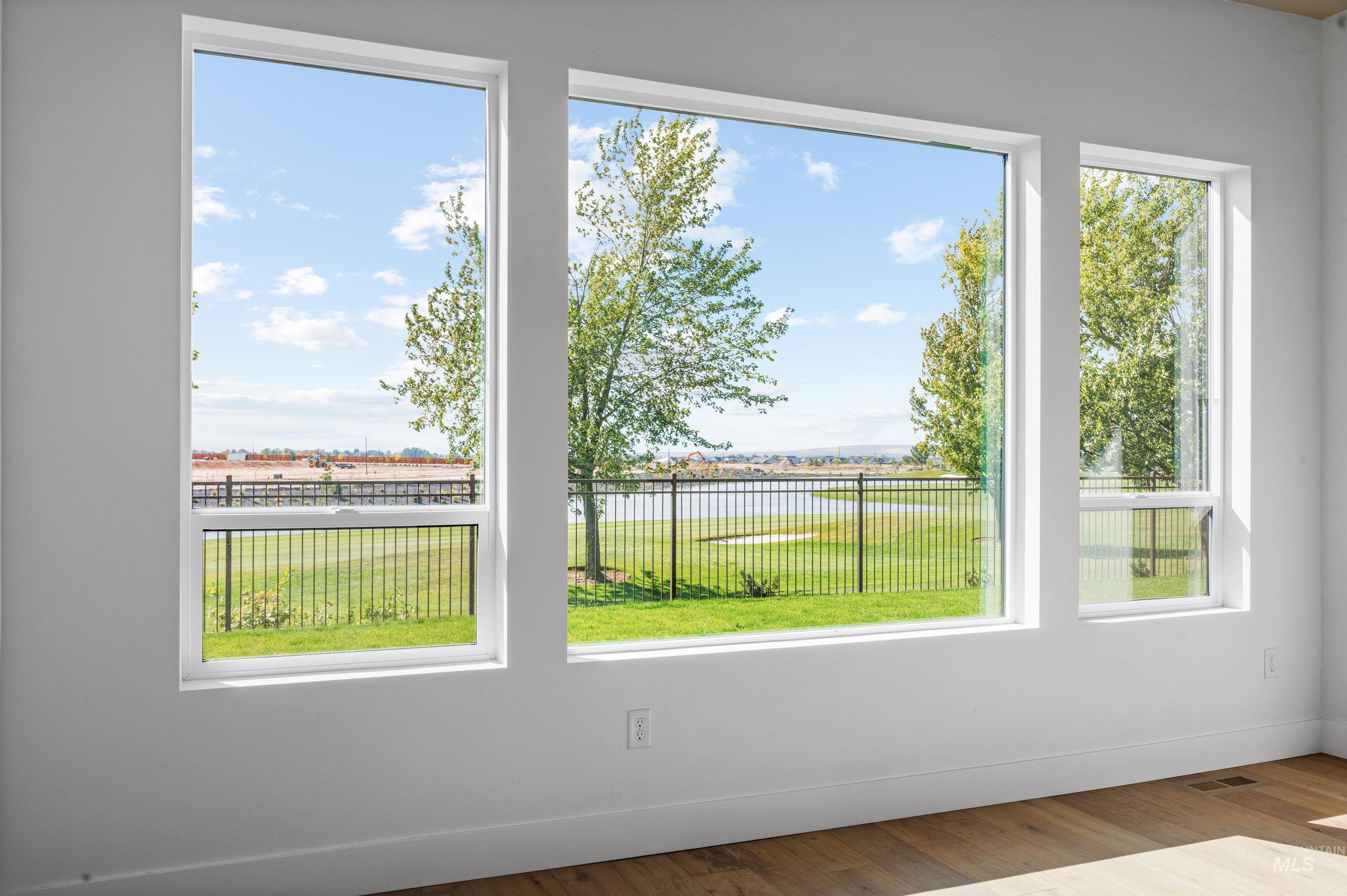 Doorway to outside featuring plenty of natural light, a water view, and wood finished floors