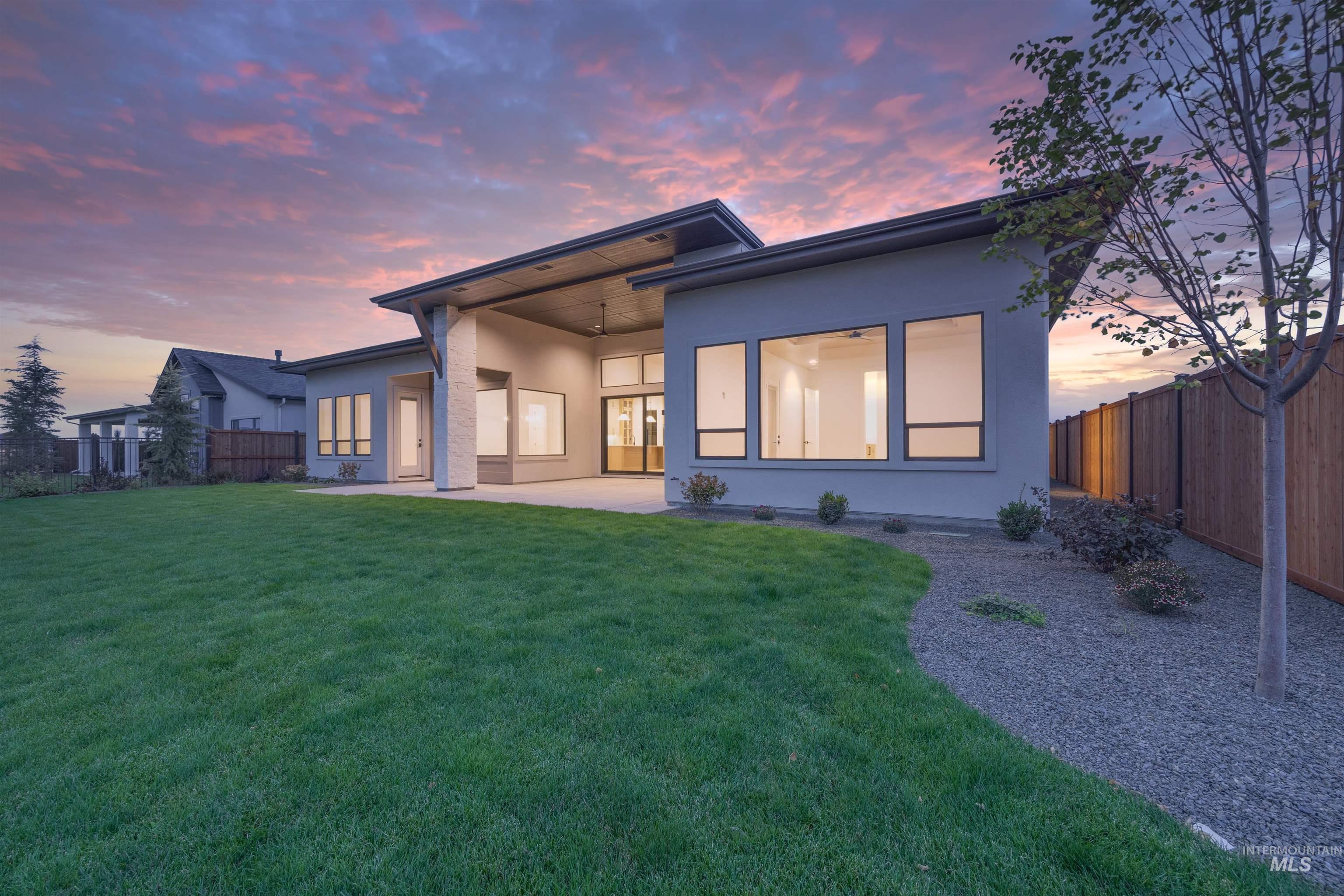 Rear view of property with a fenced backyard, stucco siding, a patio, and ceiling fan