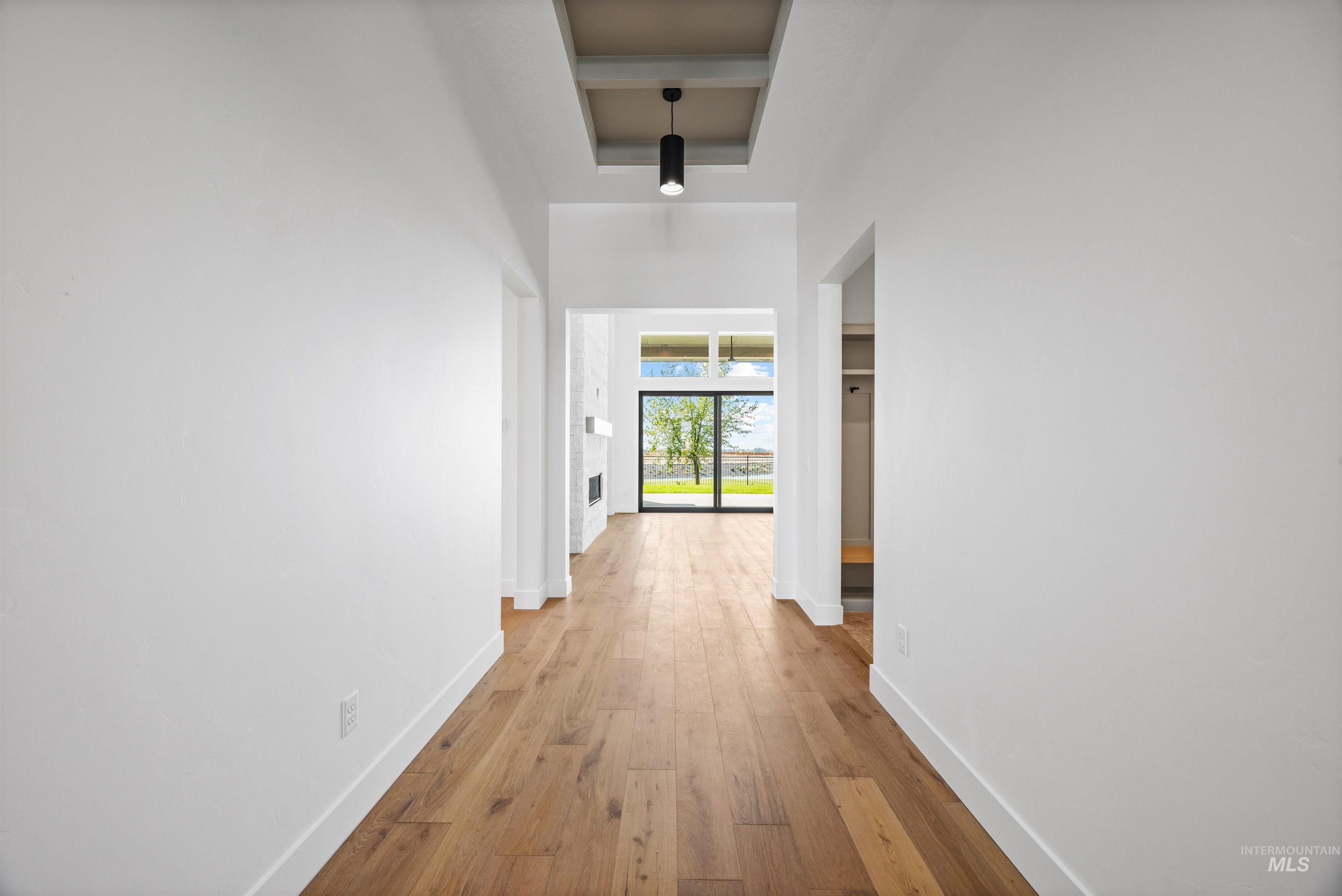 Hall with wood-type flooring and a towering ceiling