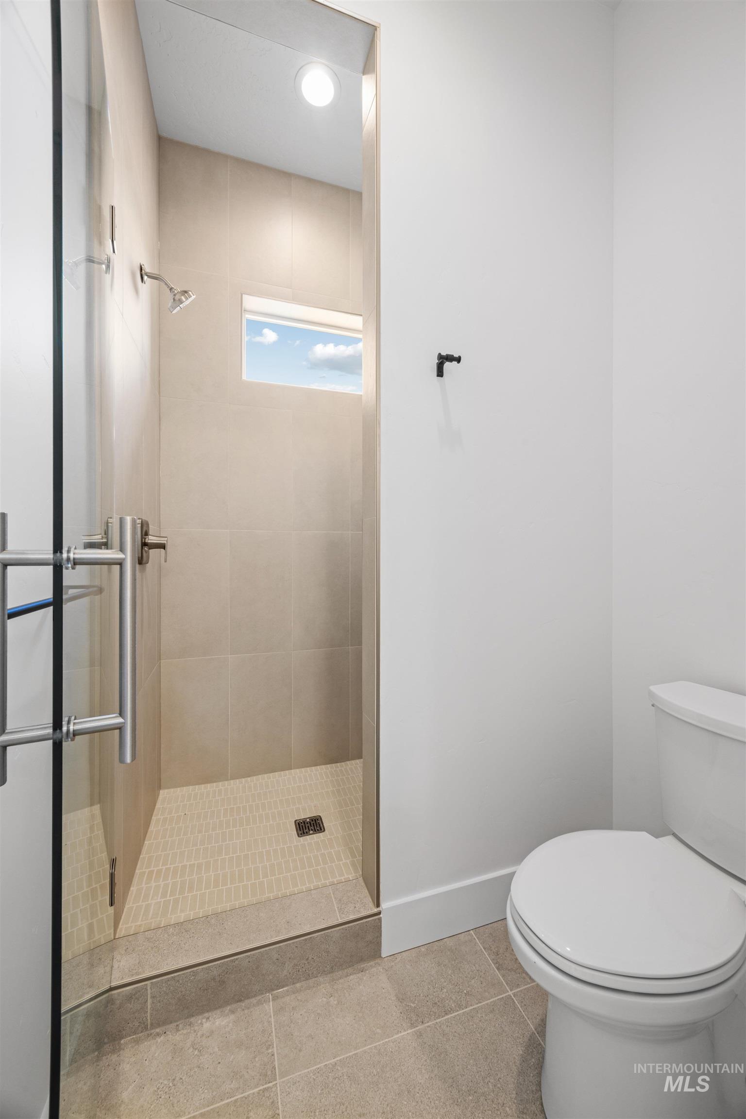 Bathroom with a stall shower and tile patterned floors