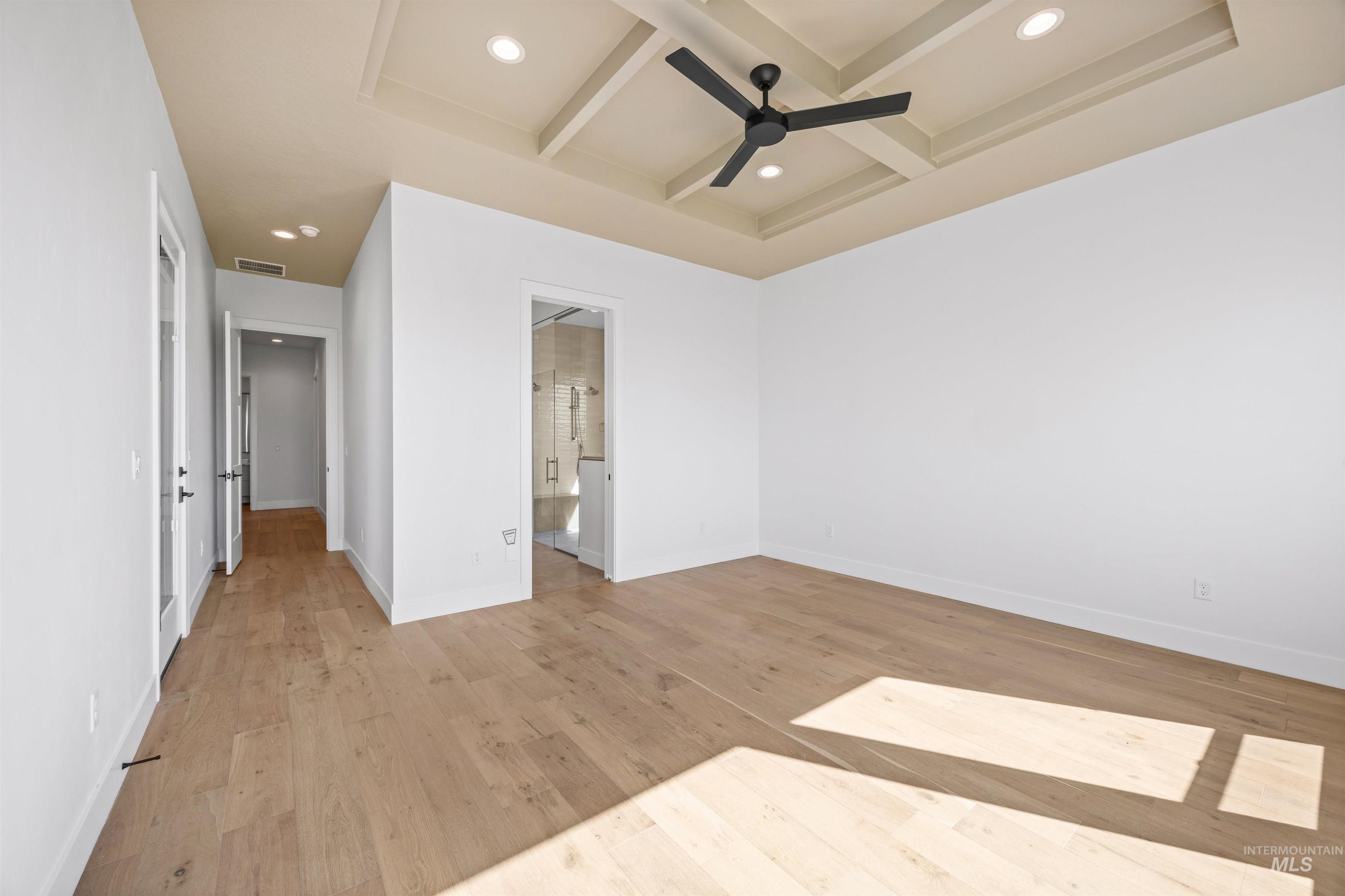 Unfurnished bedroom with recessed lighting, beam ceiling, light wood-type flooring, coffered ceiling, and a ceiling fan