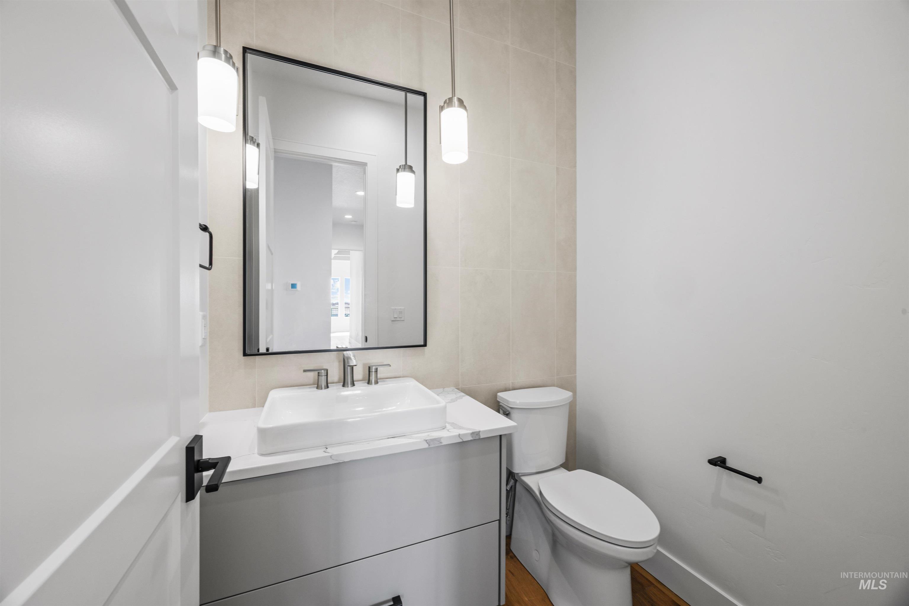 Bathroom with tile walls, vanity, and wood finished floors