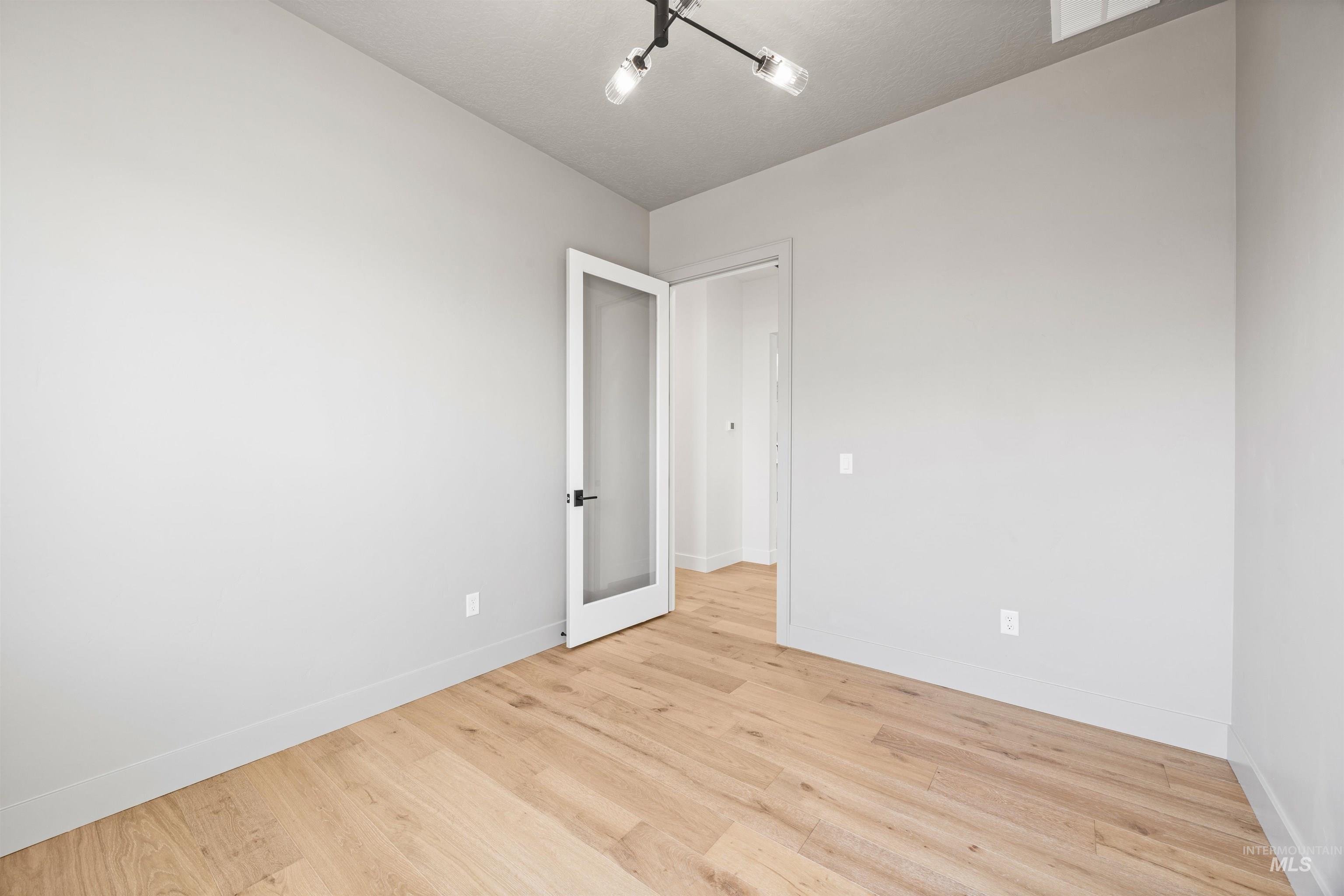 Spare room featuring light wood-style floors and baseboards