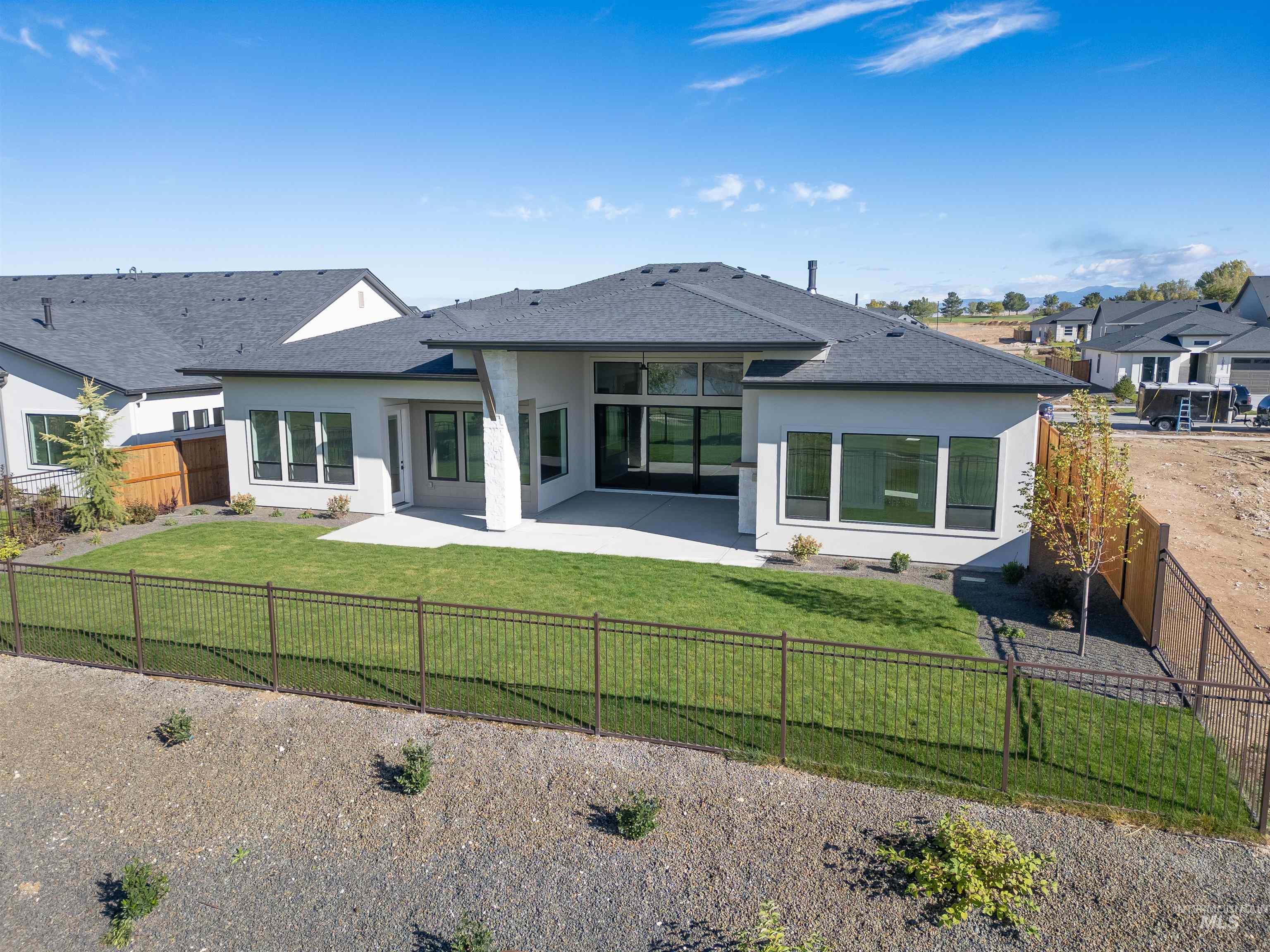 Rear view of house featuring a patio, stucco siding, and a fenced backyard