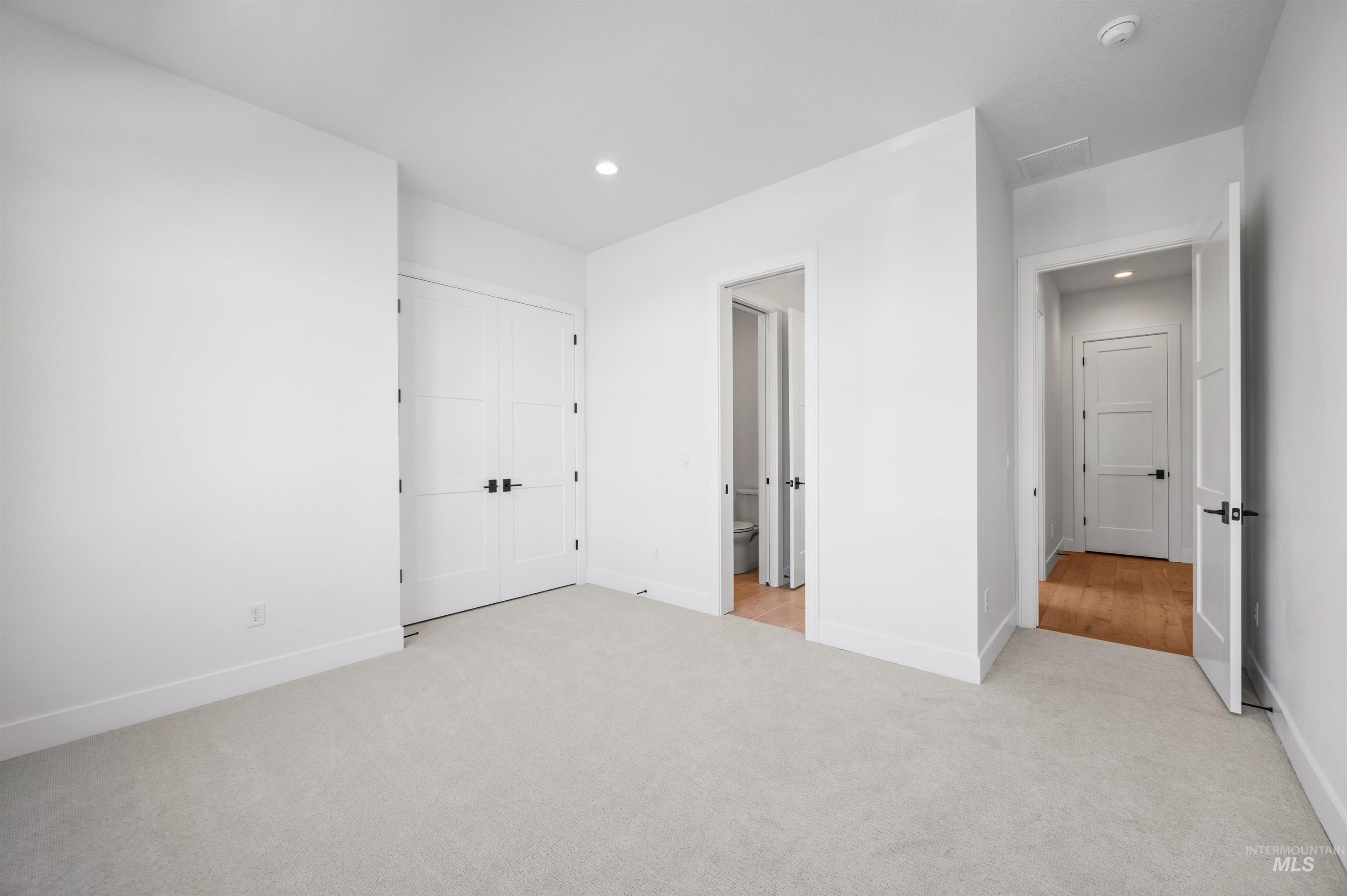 Unfurnished bedroom with light carpet, recessed lighting, and a closet
