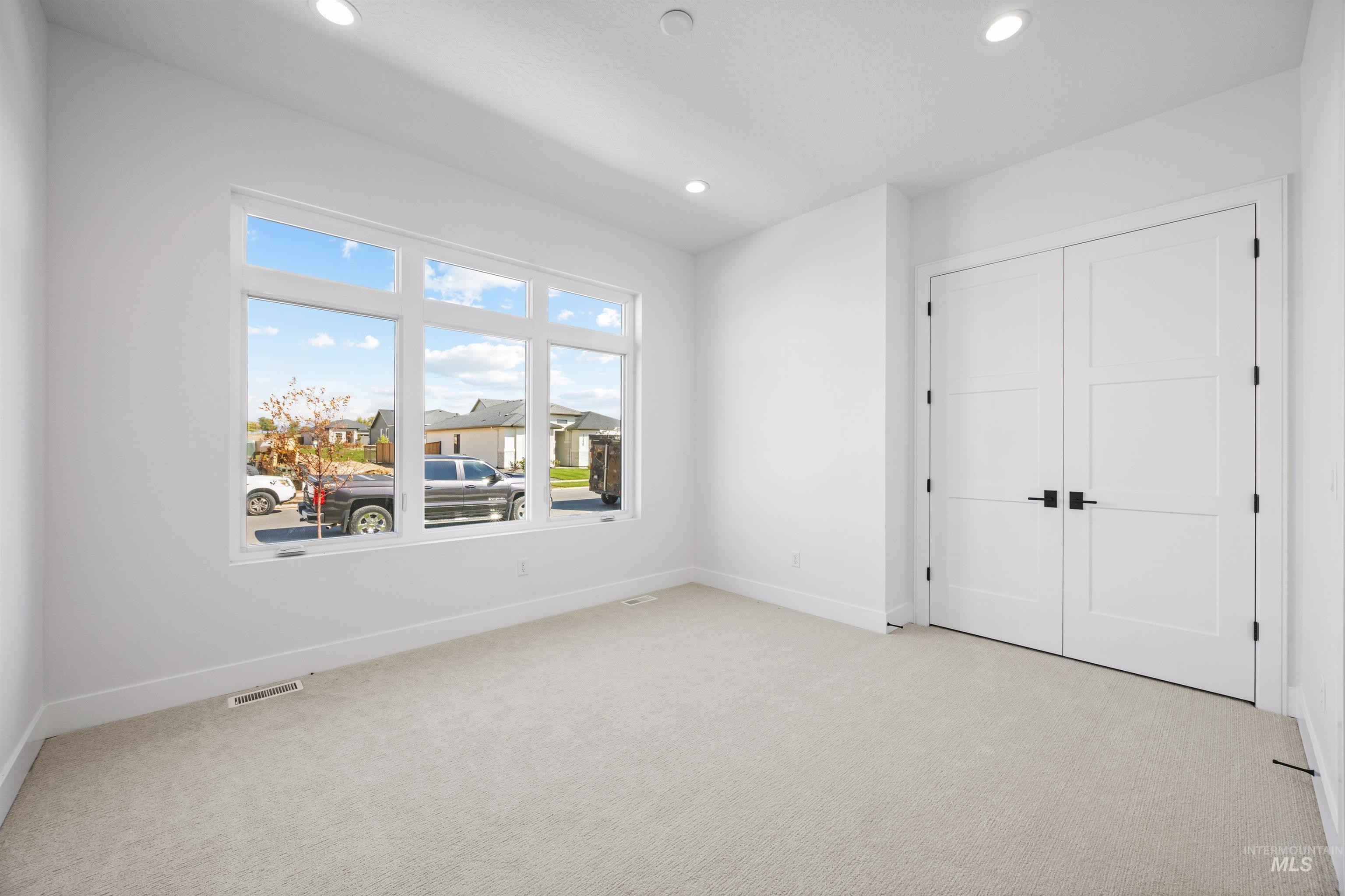 Unfurnished bedroom featuring light carpet, a closet, and recessed lighting