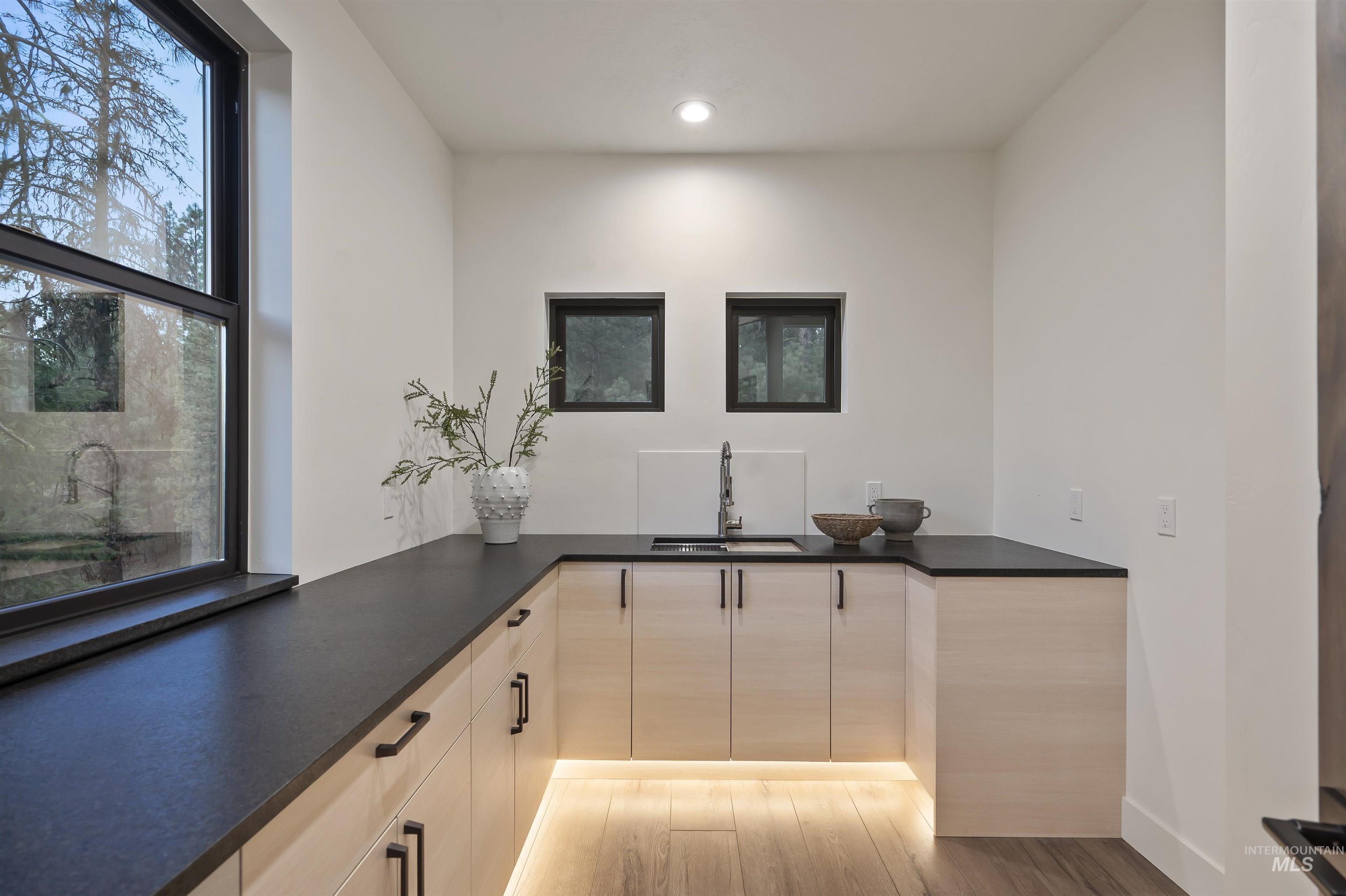 Bar area with light wood-style flooring and recessed lighting