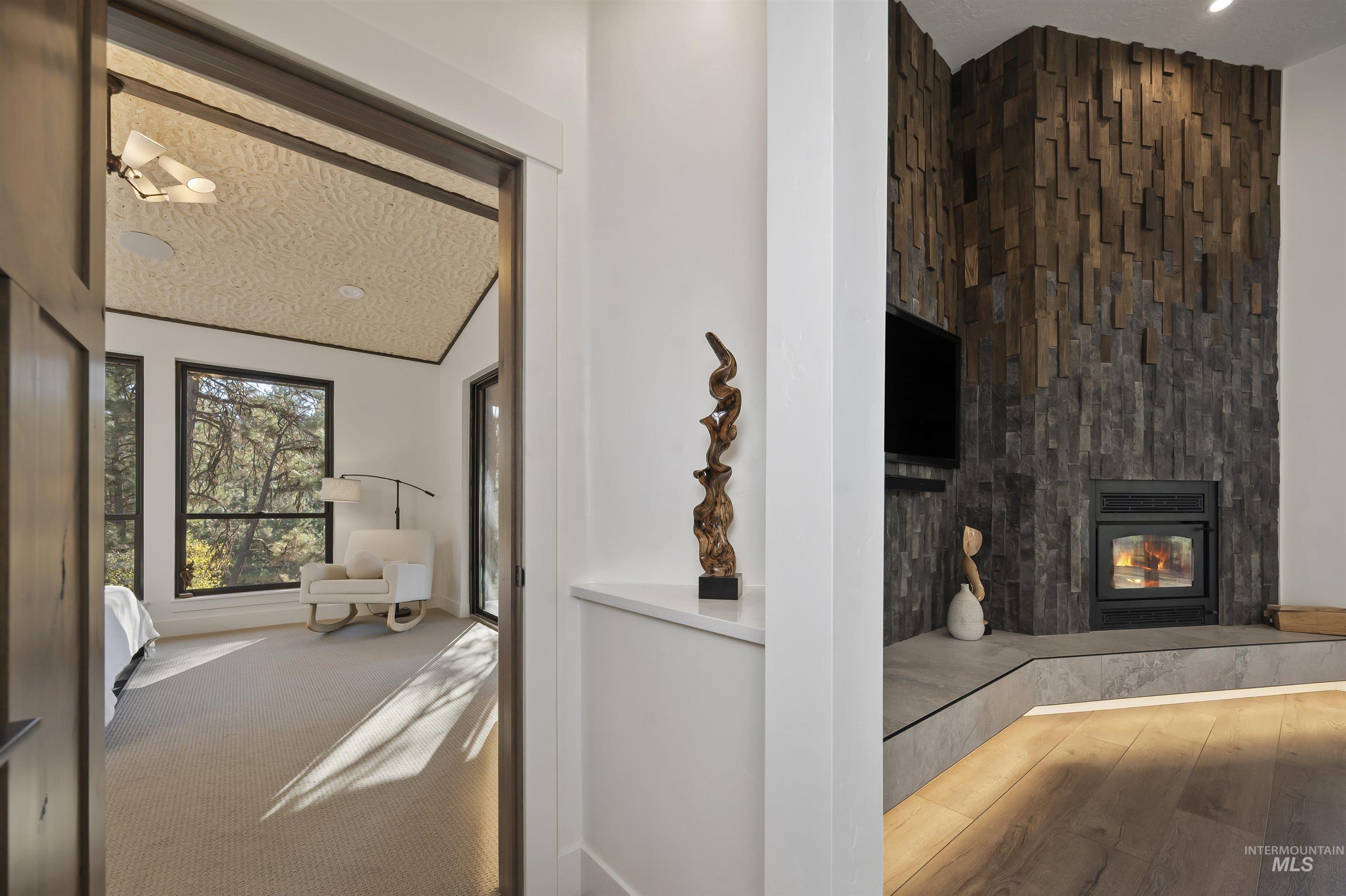 Unfurnished living room with a glass covered fireplace and wood finished floors