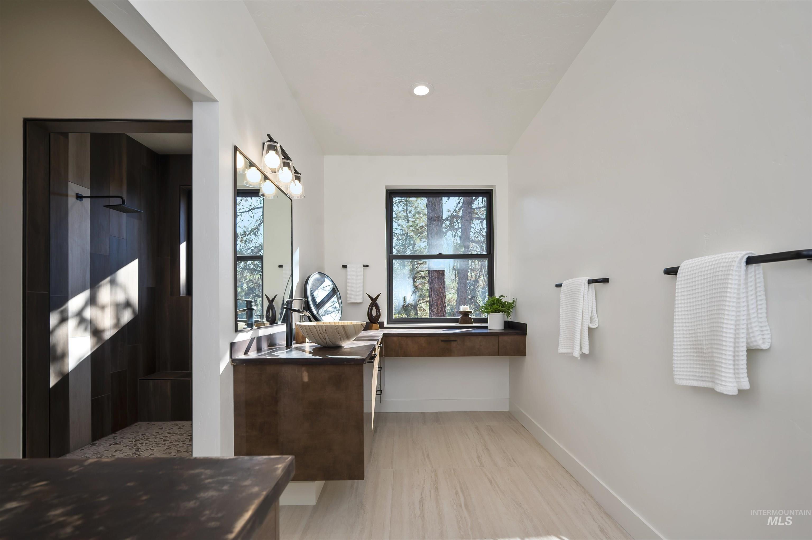 Bathroom featuring vanity, tiled shower, recessed lighting, and wood finished floors