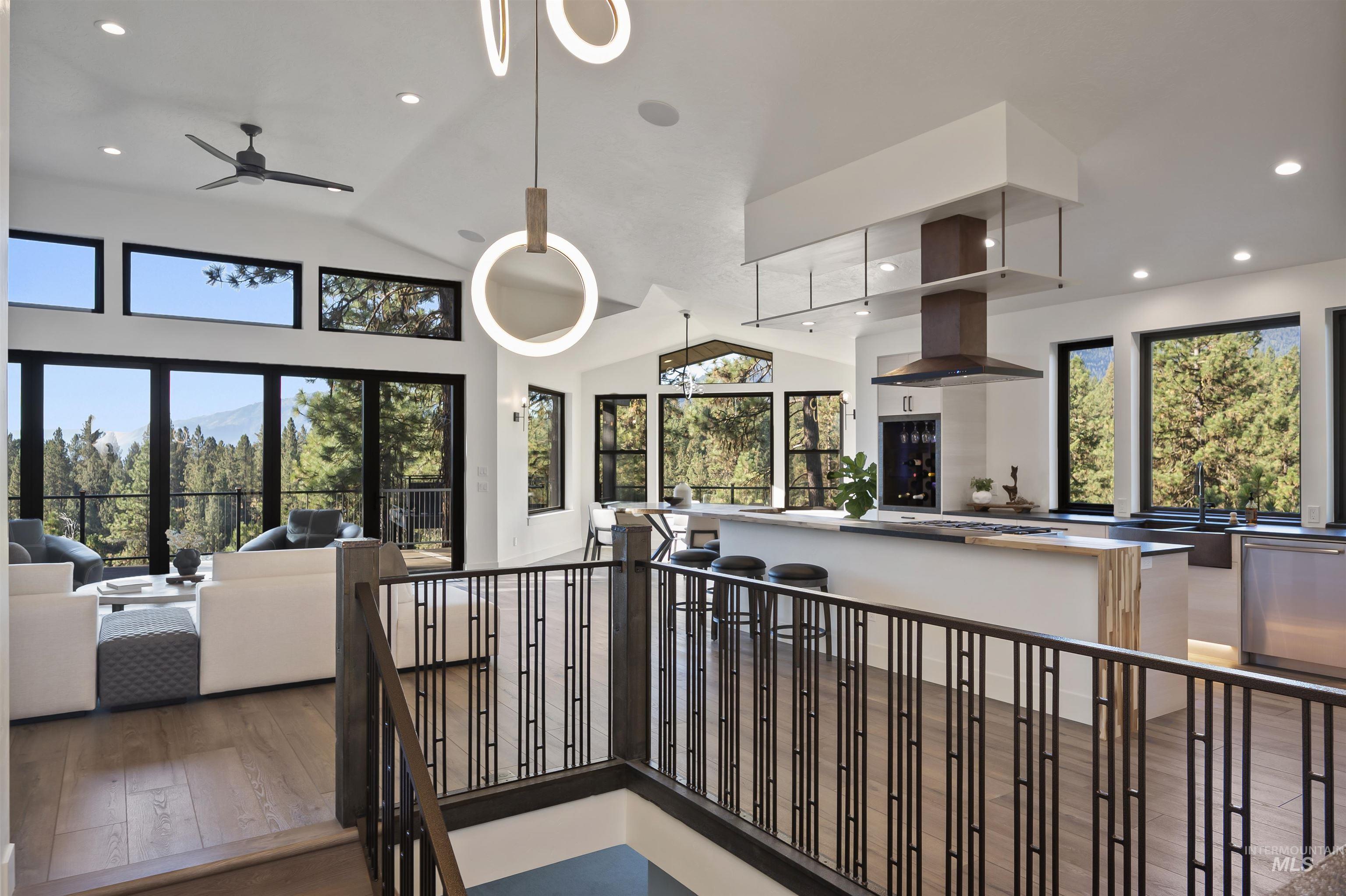 Kitchen featuring open floor plan, recessed lighting, vaulted ceiling, wood finished floors, and dishwasher