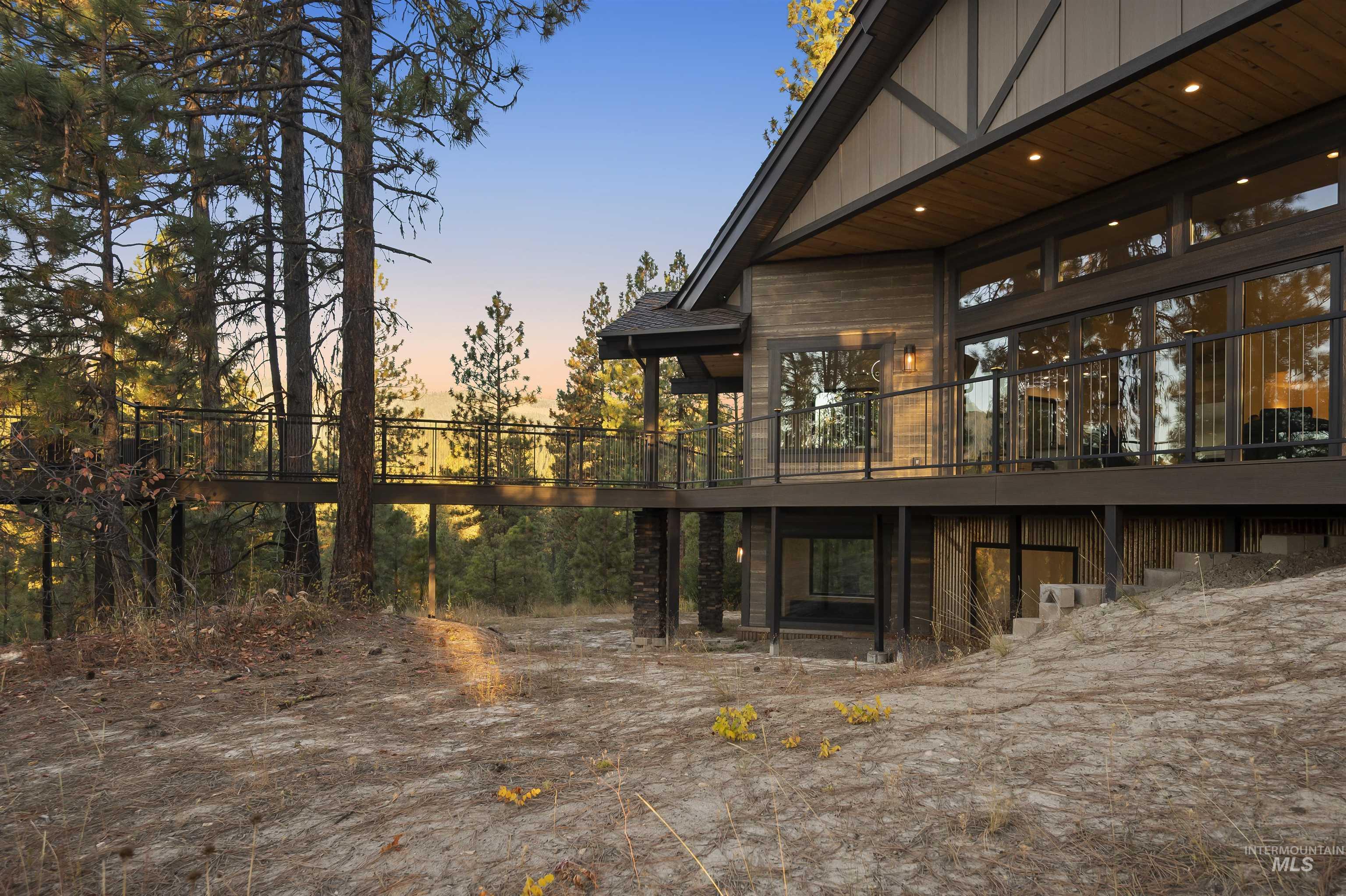 Back of house at dusk featuring a wooden deck