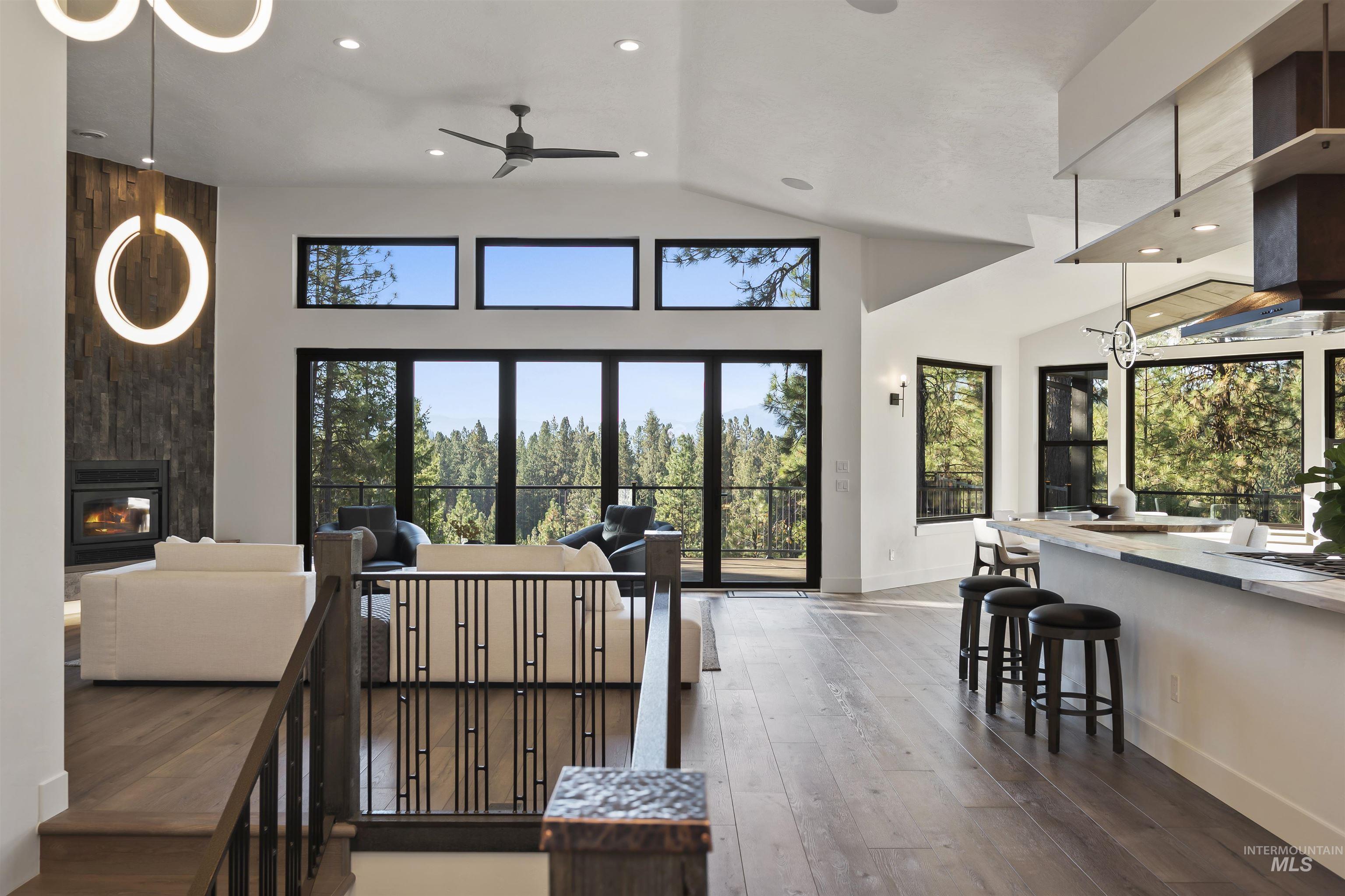 Living area featuring recessed lighting, wood-type flooring, ceiling fan, vaulted ceiling, and a fireplace