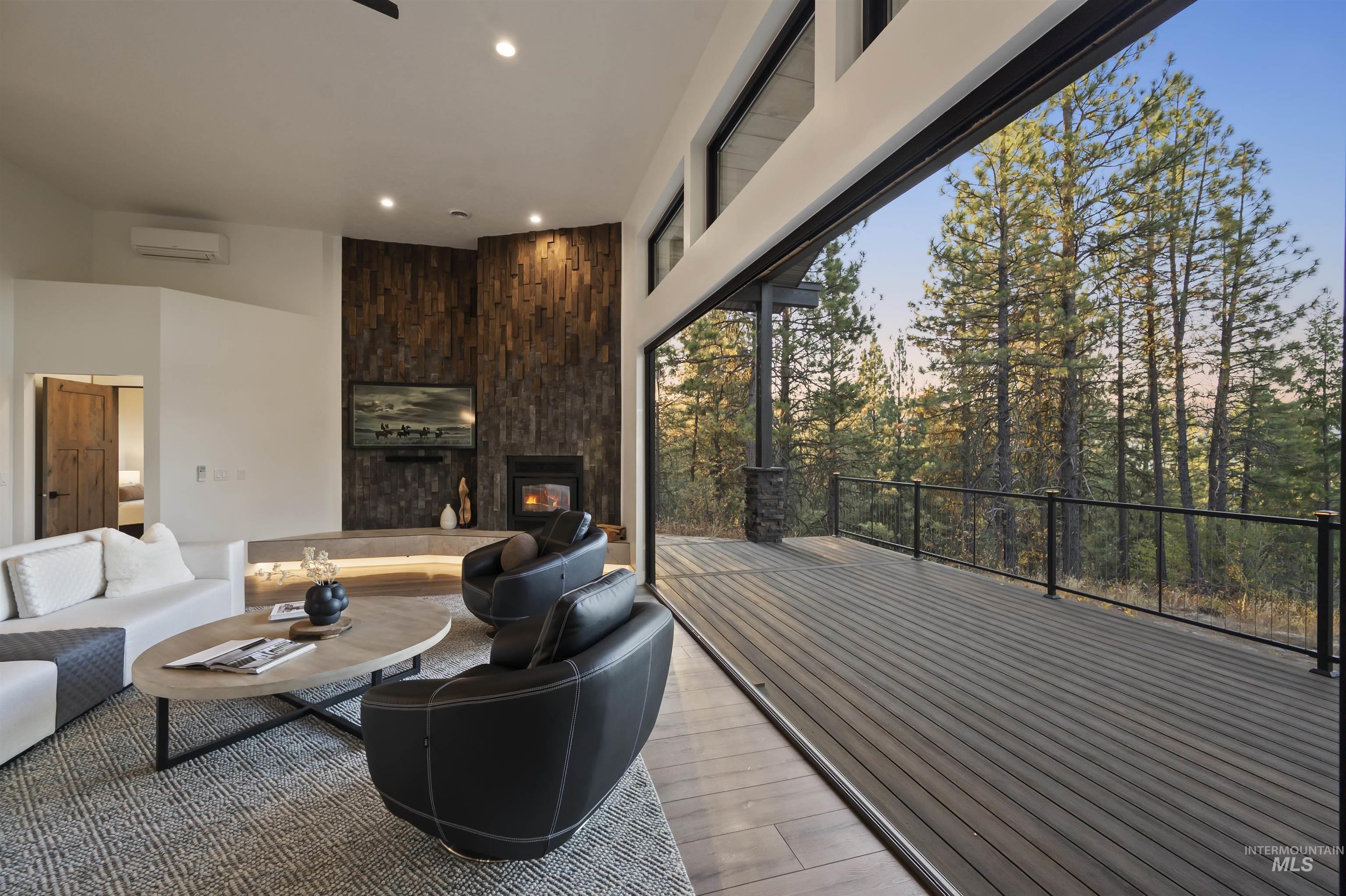 Living room with light wood-style flooring, a fireplace, recessed lighting, an AC wall unit, and a high ceiling