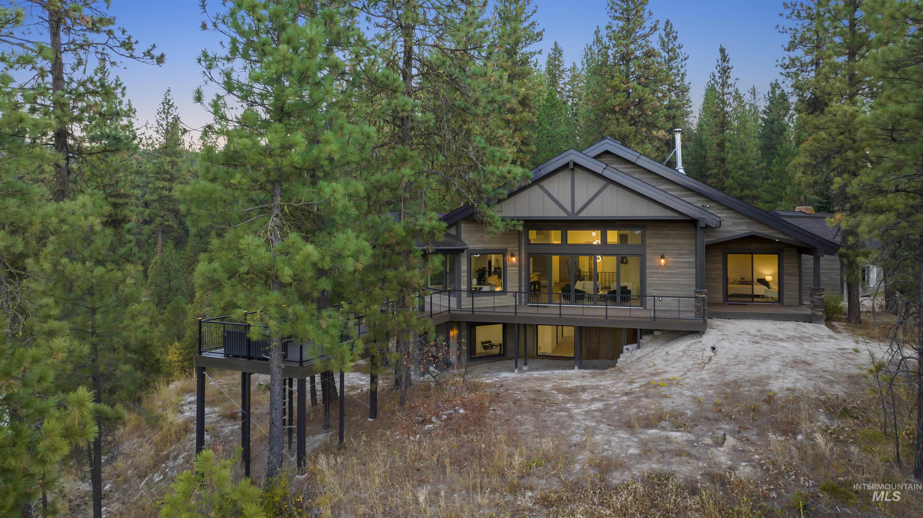 Back of property with a deck and a view of trees
