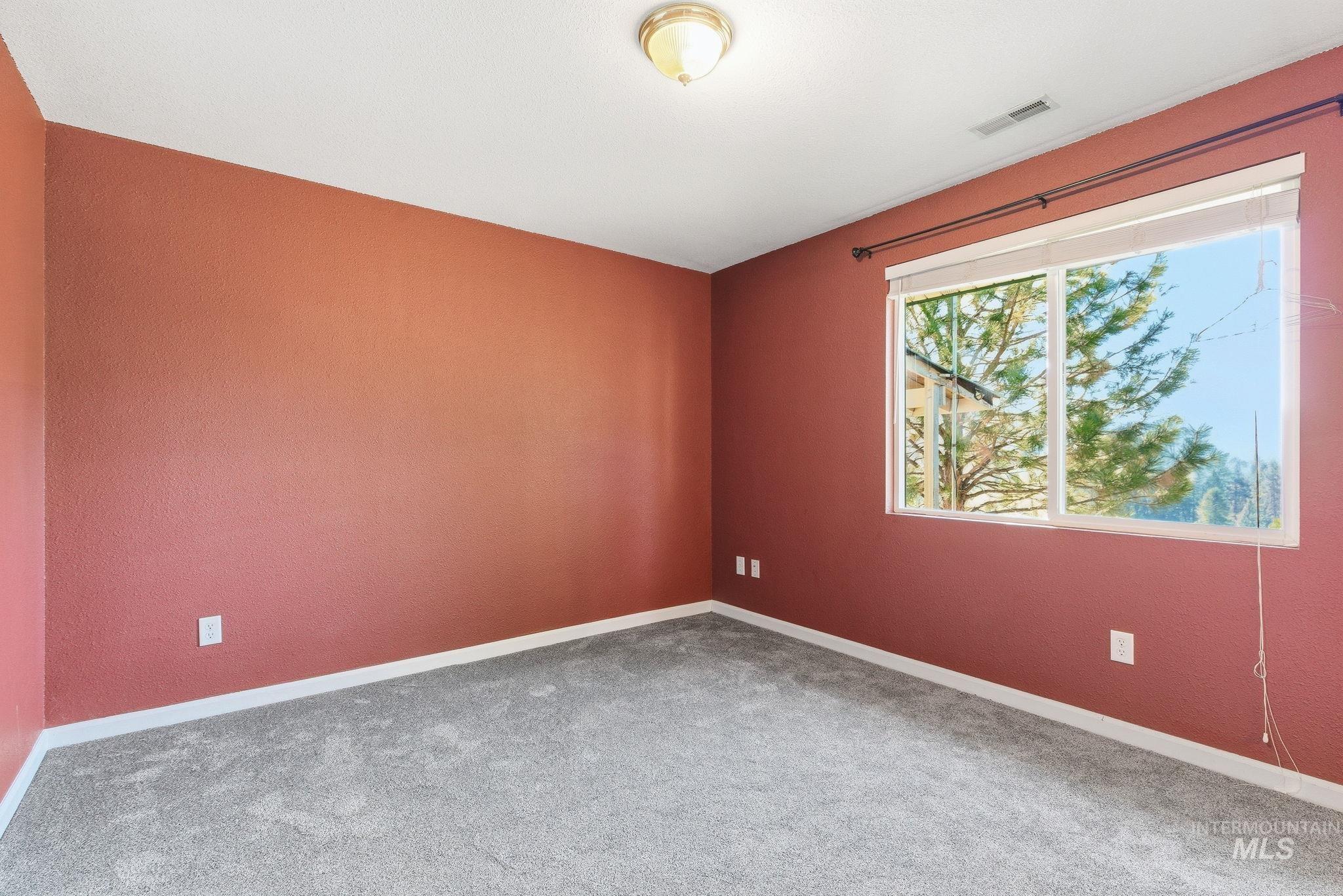 Spare room featuring carpet floors and baseboards