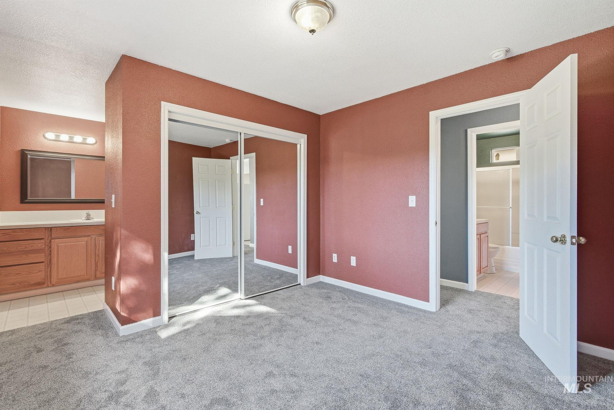 Unfurnished bedroom featuring light colored carpet, light tile patterned floors, and a closet