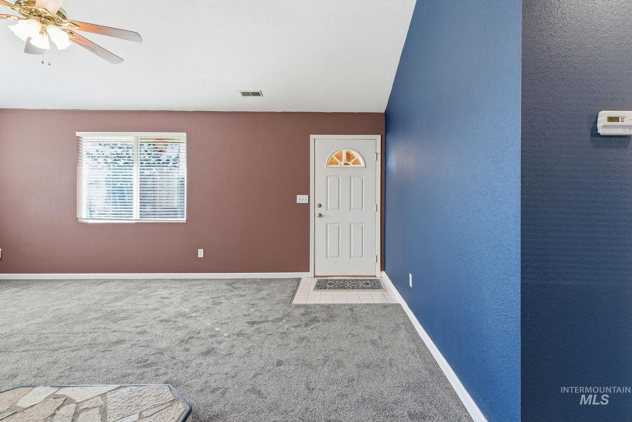 Entrance to property featuring a ceiling fan