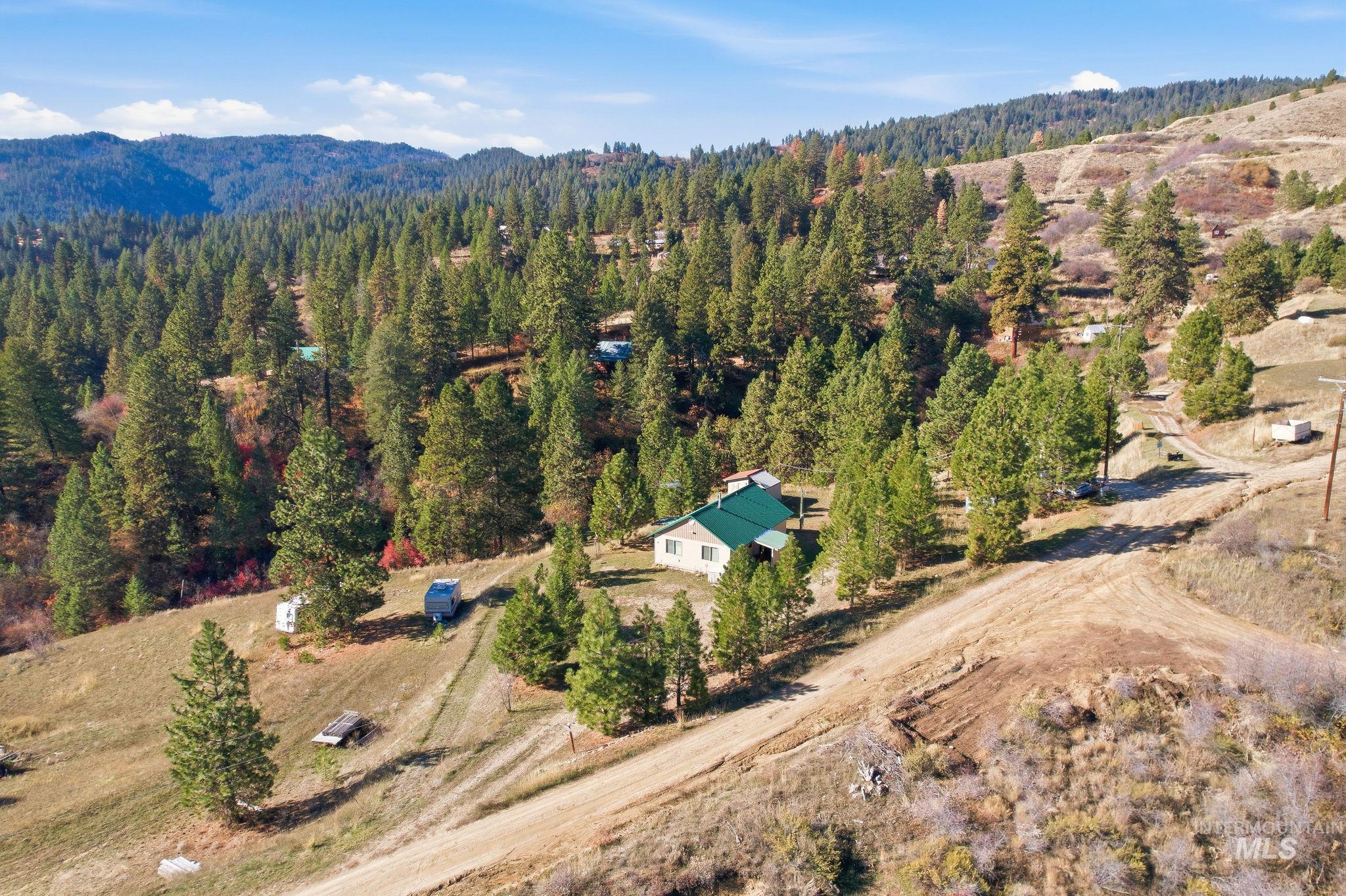 Aerial overview of property's location featuring a heavily wooded area and a mountain backdrop
