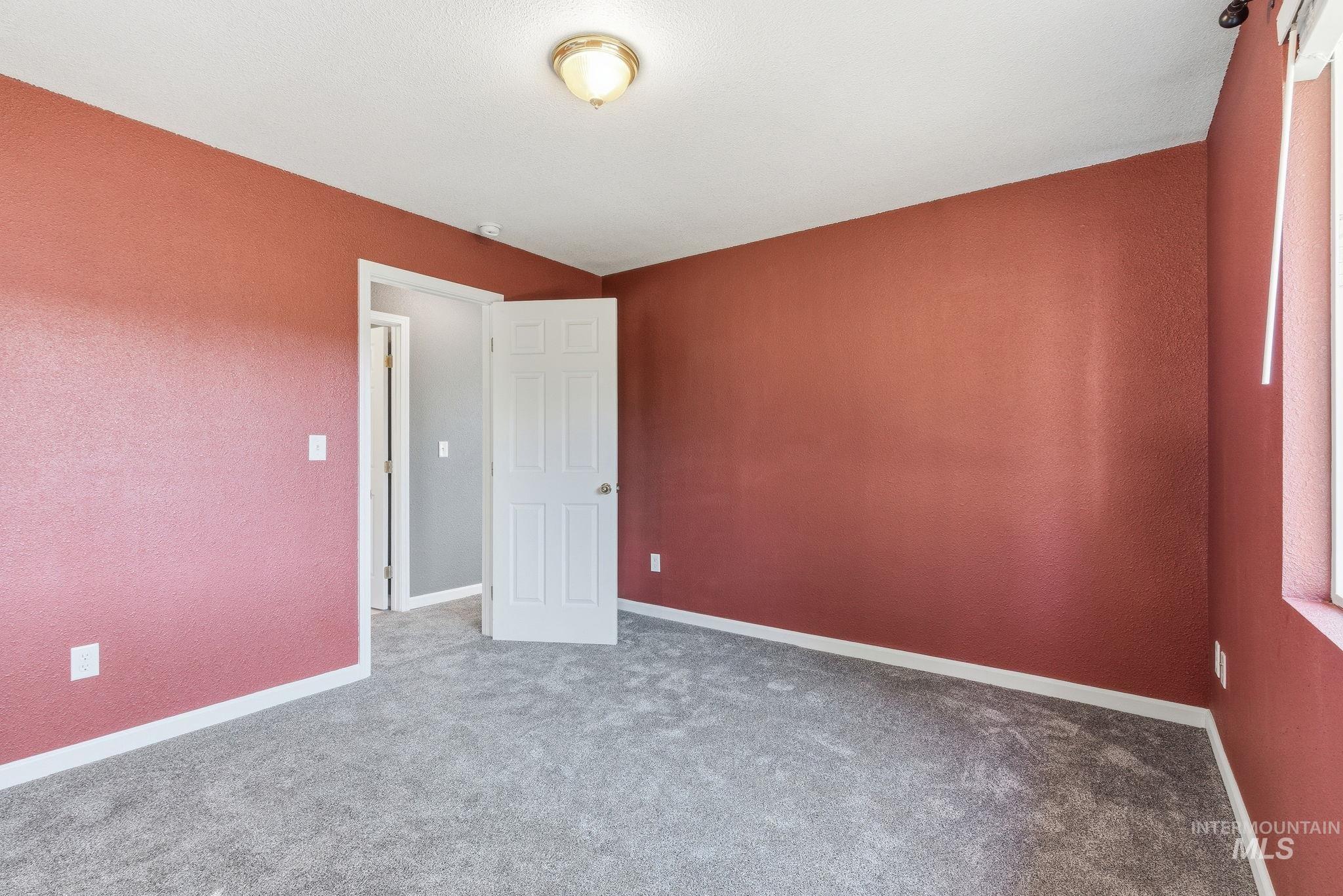 Spare room featuring carpet and baseboards