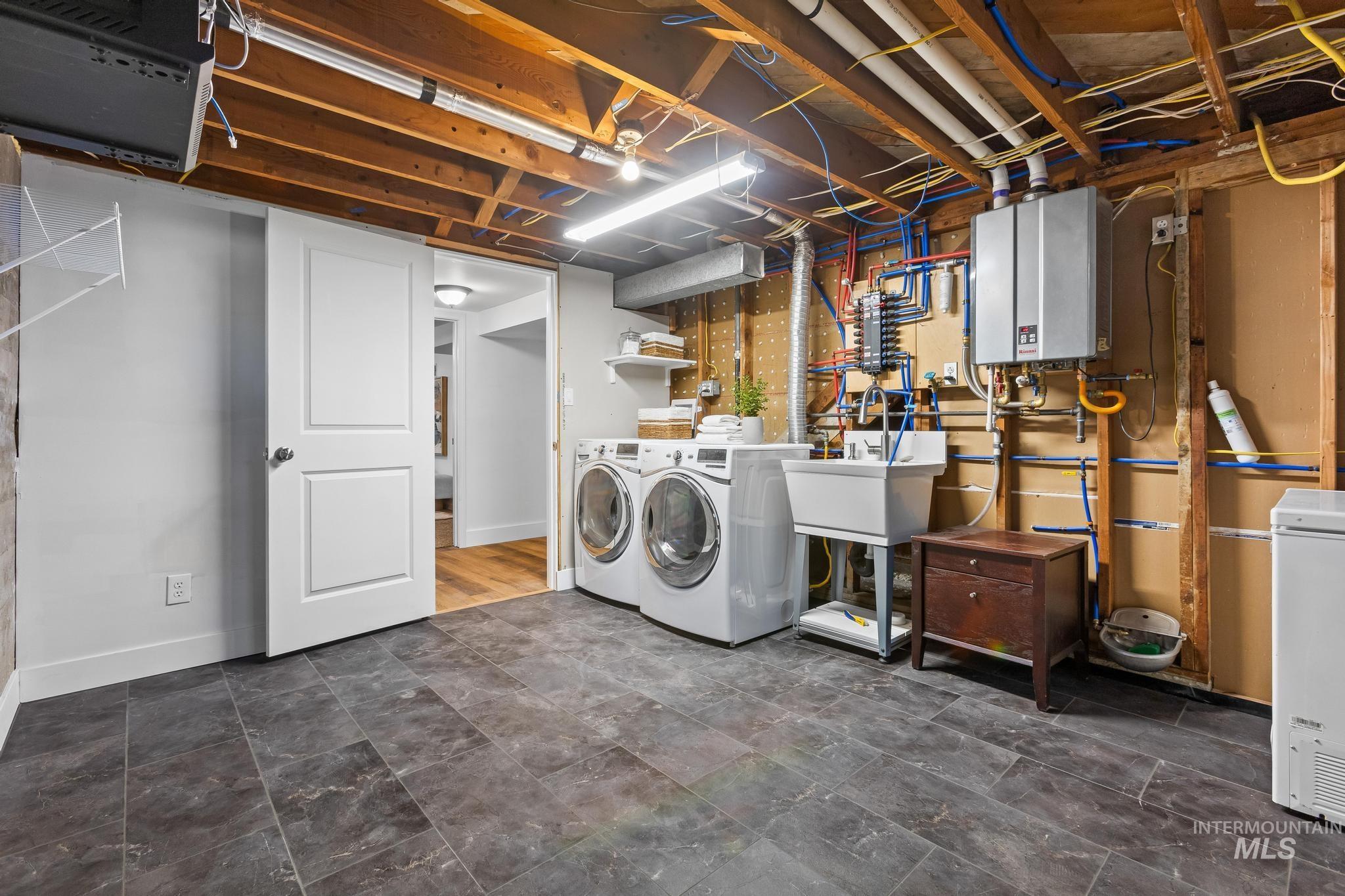 Laundry room with washing machine and clothes dryer and tankless water heater