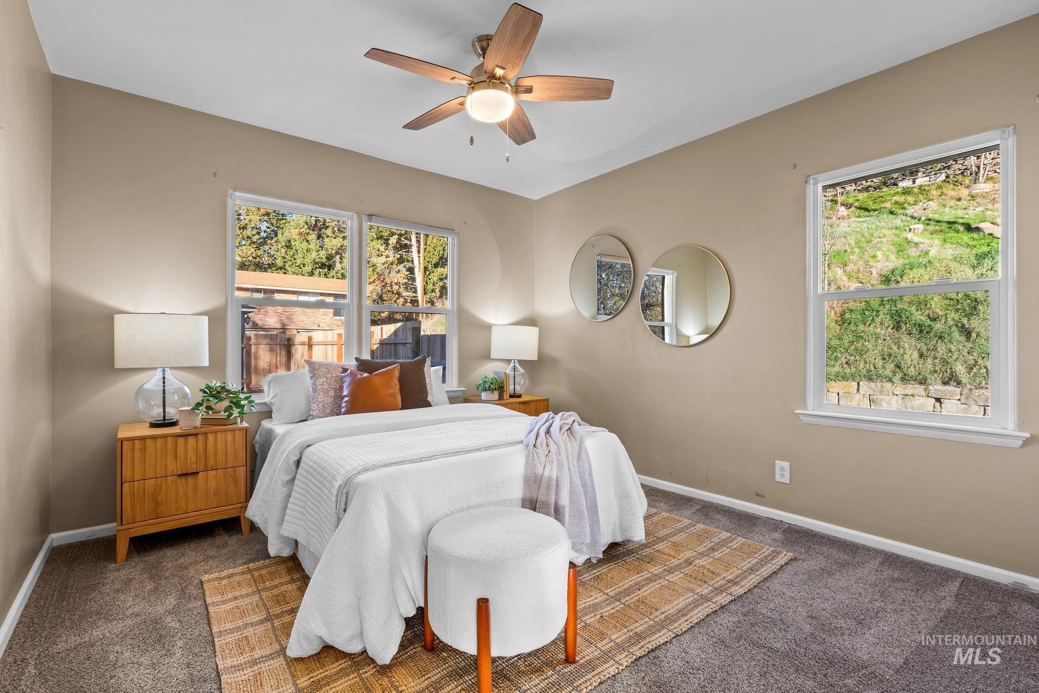 Carpeted bedroom featuring a ceiling fan and baseboards
