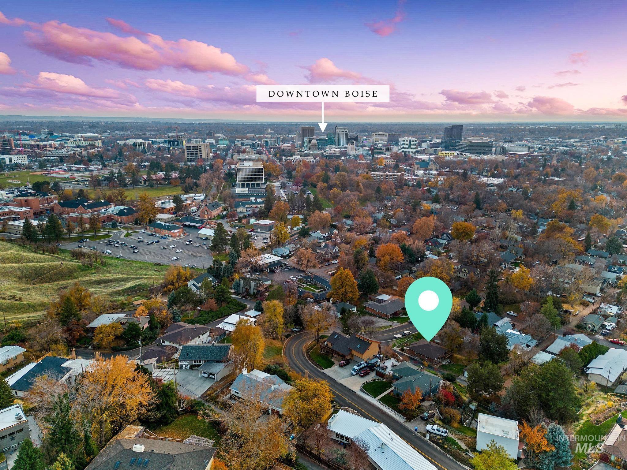 Aerial view of property and surrounding area featuring nearby suburban area