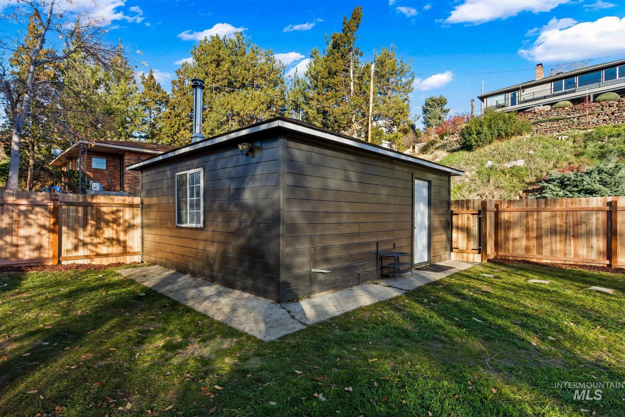 View of side of property featuring a fenced backyard and an outdoor structure