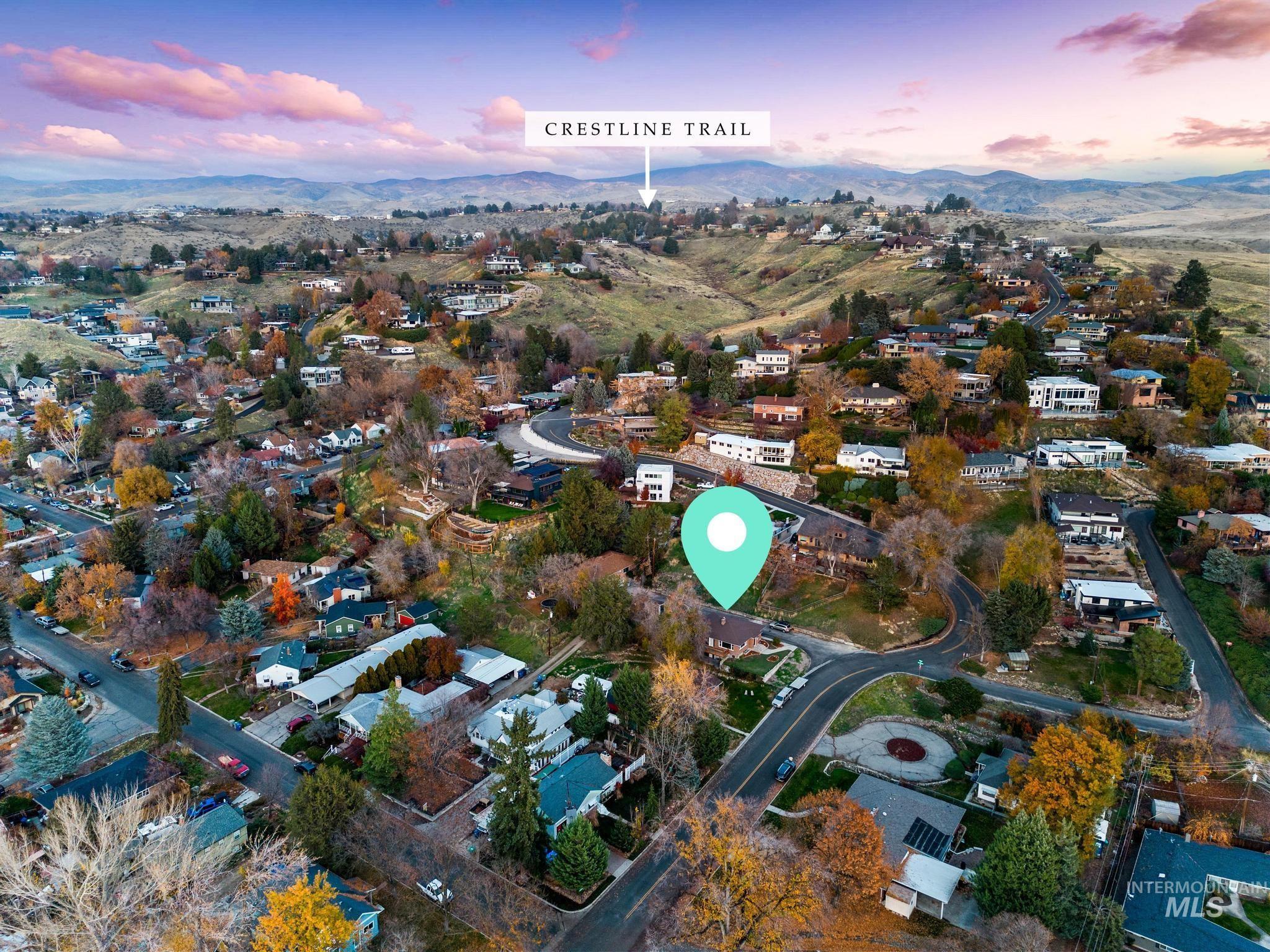 Aerial view of property and surrounding area featuring nearby suburban area and a mountainous background