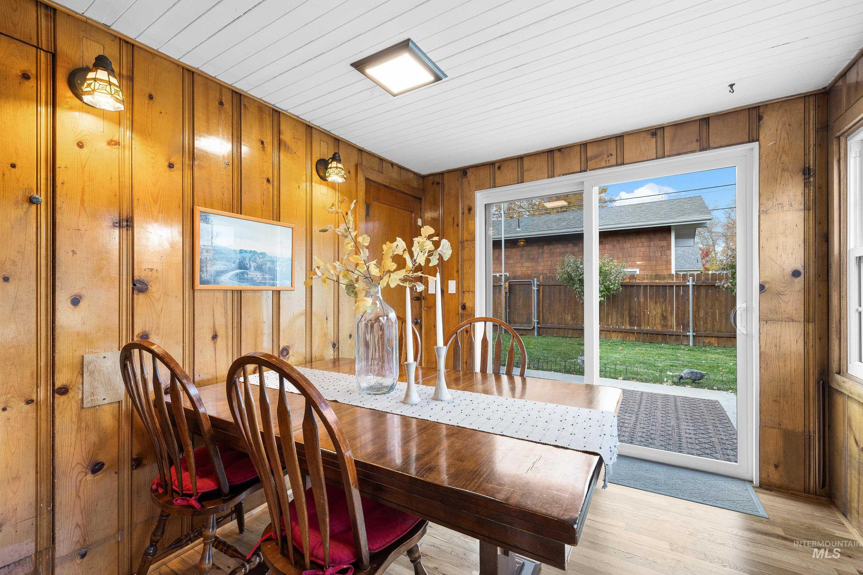 Dining space with wood finished floors, wood walls, and wood ceiling