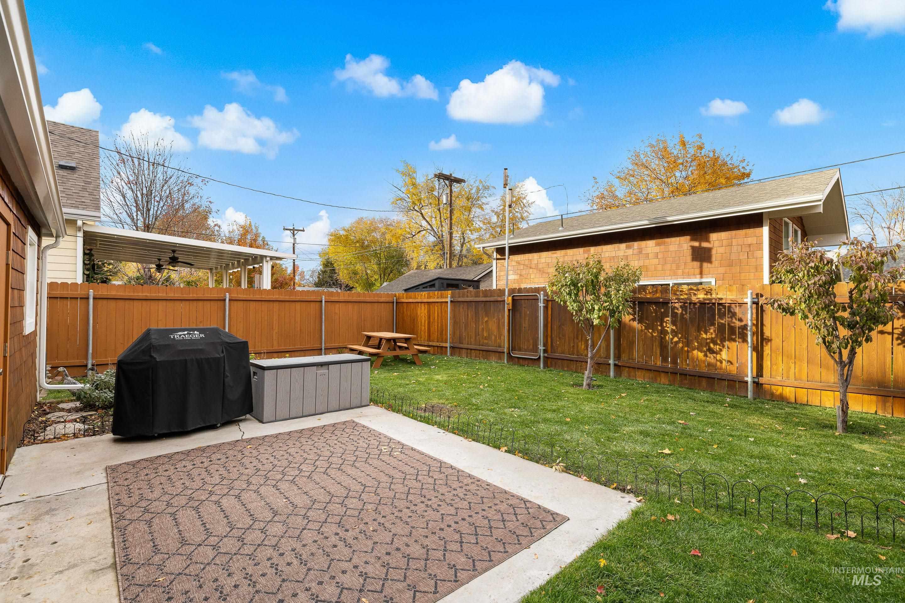 Fenced backyard featuring a patio and ceiling fan