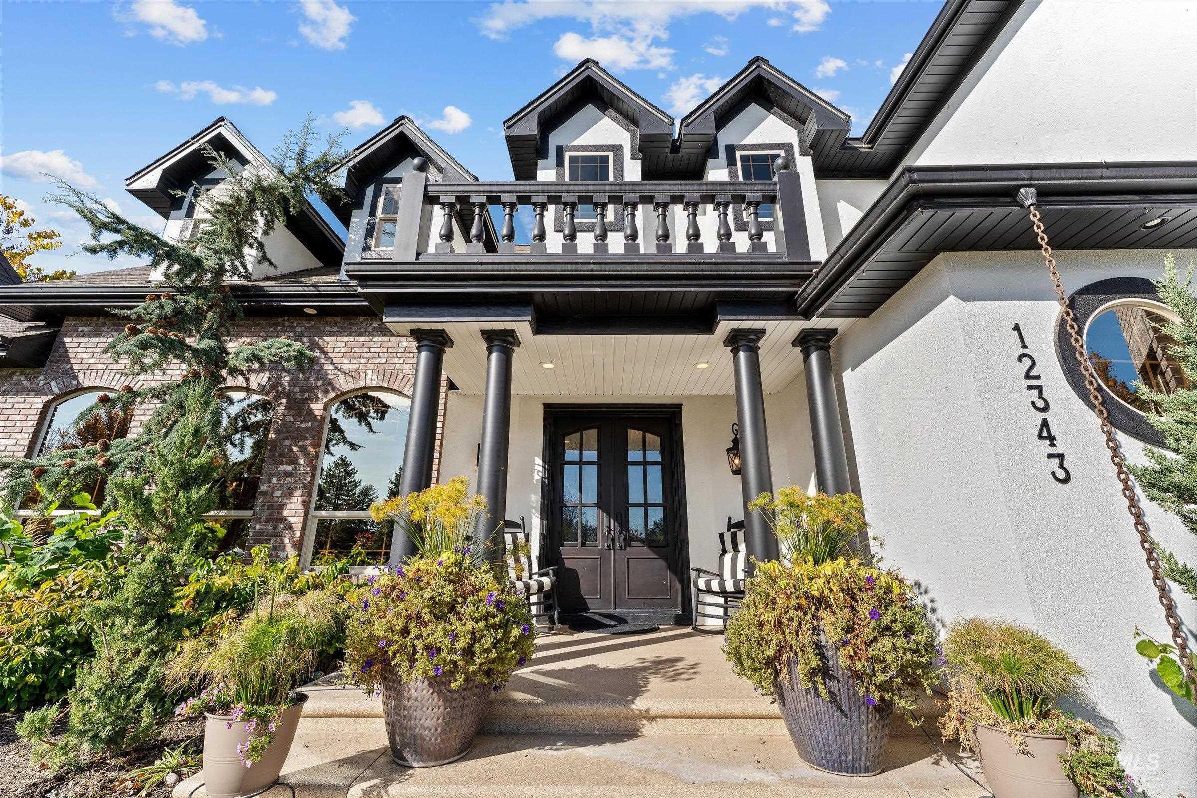 Doorway to property with stucco siding, covered porch, and french doors