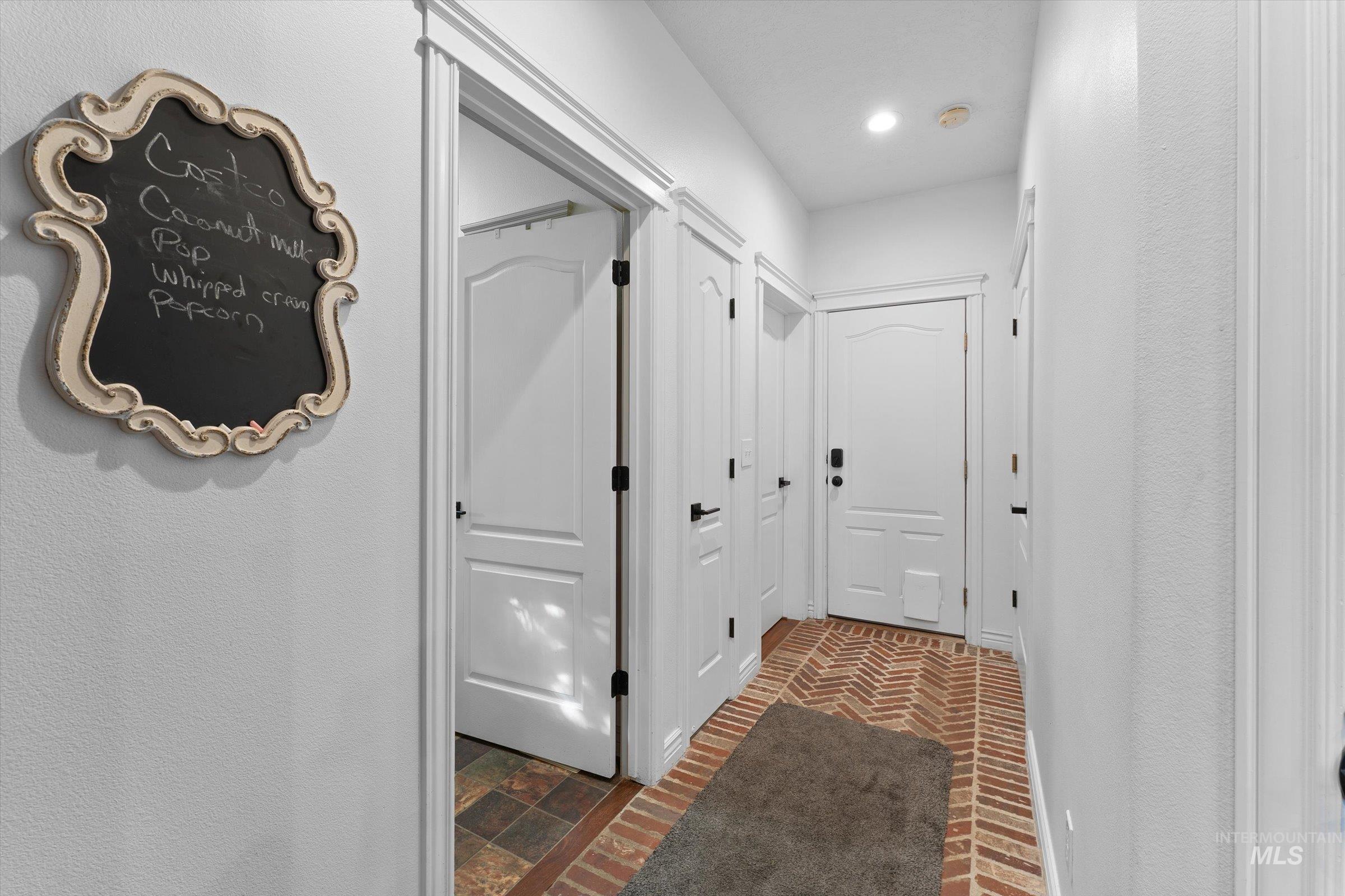 Hallway featuring brick floors