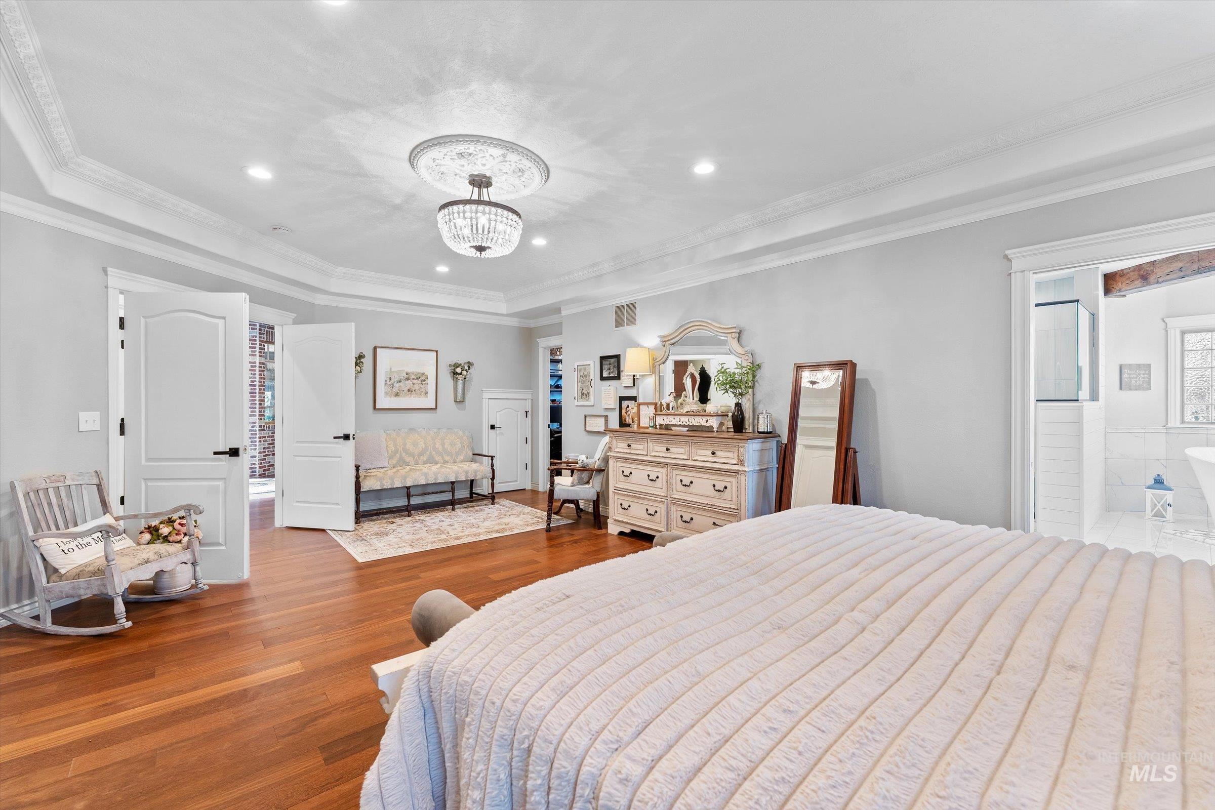 Bedroom featuring ornamental molding, wood finished floors, recessed lighting, and a chandelier